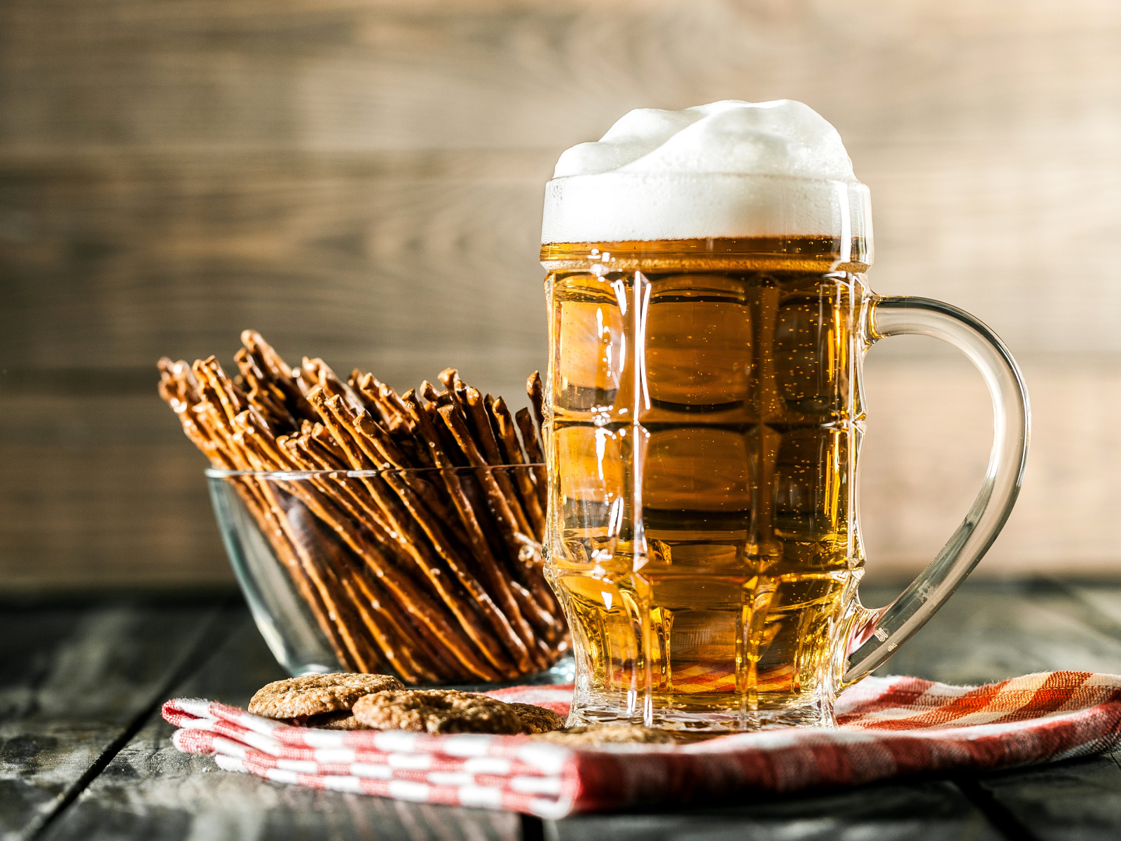 Бокал свежего пива с выпечкой на столе