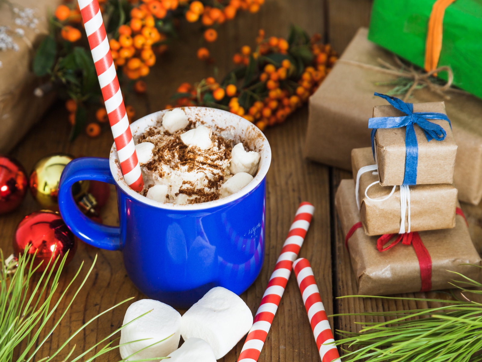 Сладкий напиток с маршмеллоу на столе с подарками на Новый год