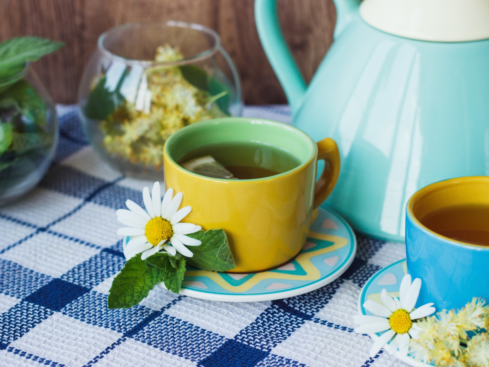Чай с цветами ромашки в желтой чашке на столе