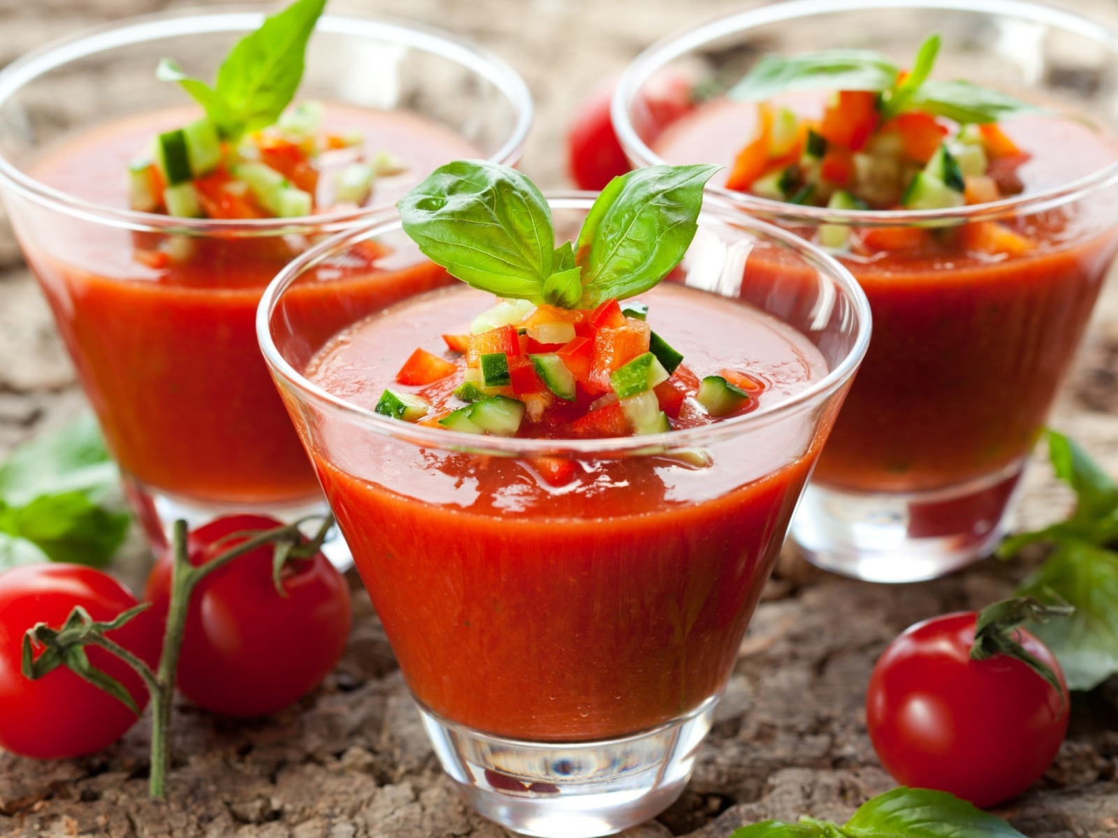 Три стакана томатного сока с овощами на столе