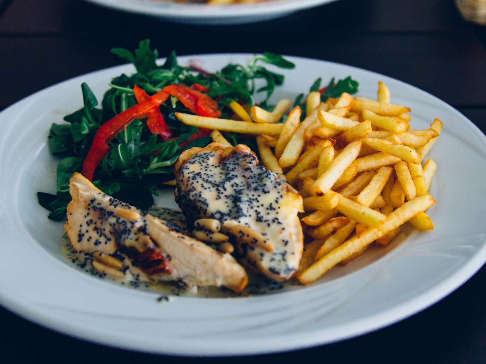 Курица с картофелем фри и салатом на большой белой тарелке