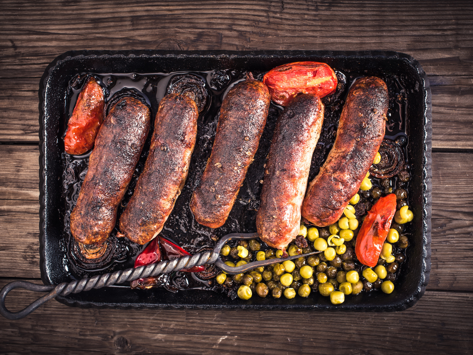 Жареные аппетитные сосиски с овощами 