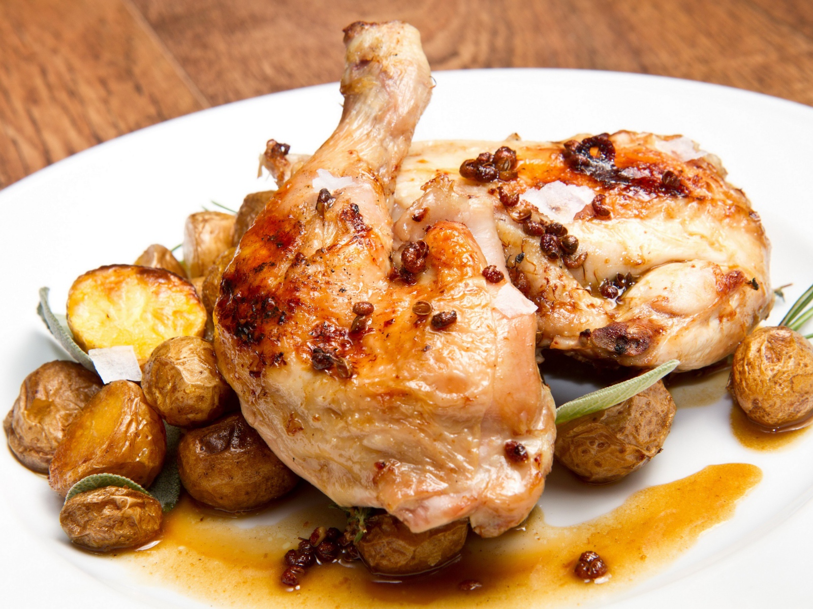 Жареные окорочка с картофелем на белой тарелке