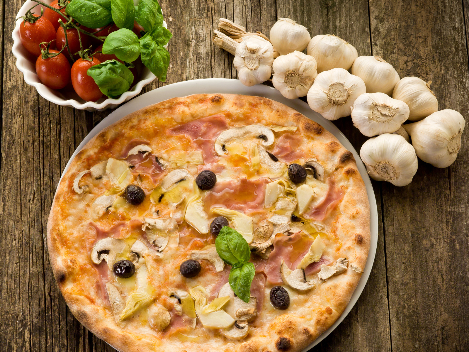 Свежая пицца с грибами на столе с чесноком и помидорами