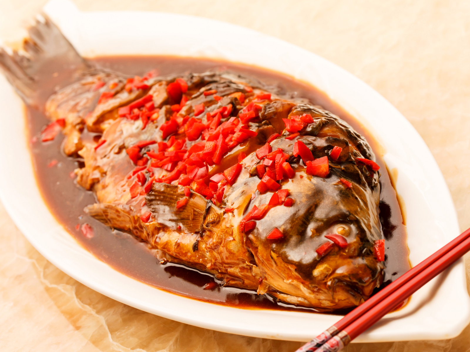 Жареная рыба с соусом и красным перцем в белом блюде