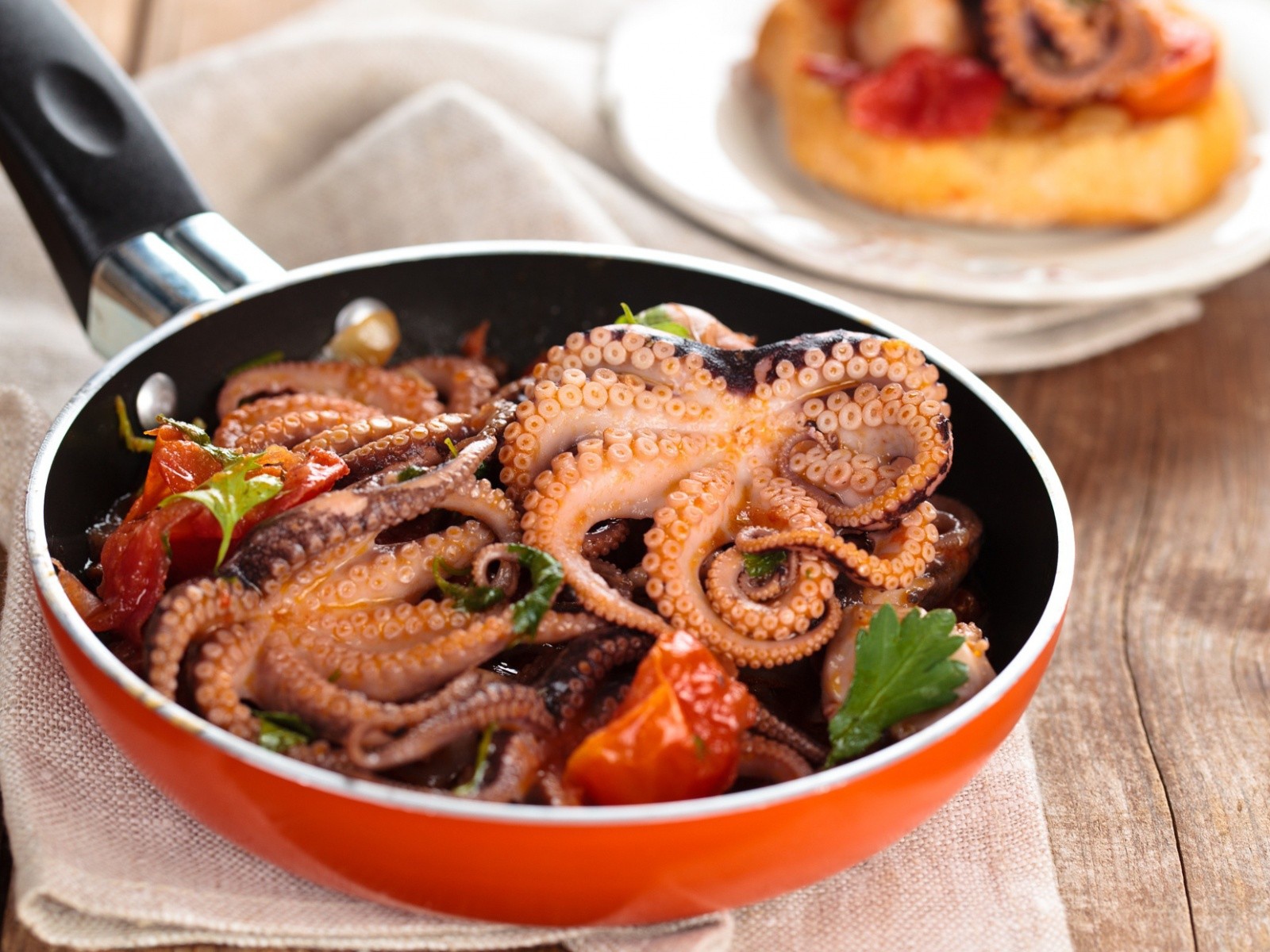 Осьминоги в сковороде на столе 