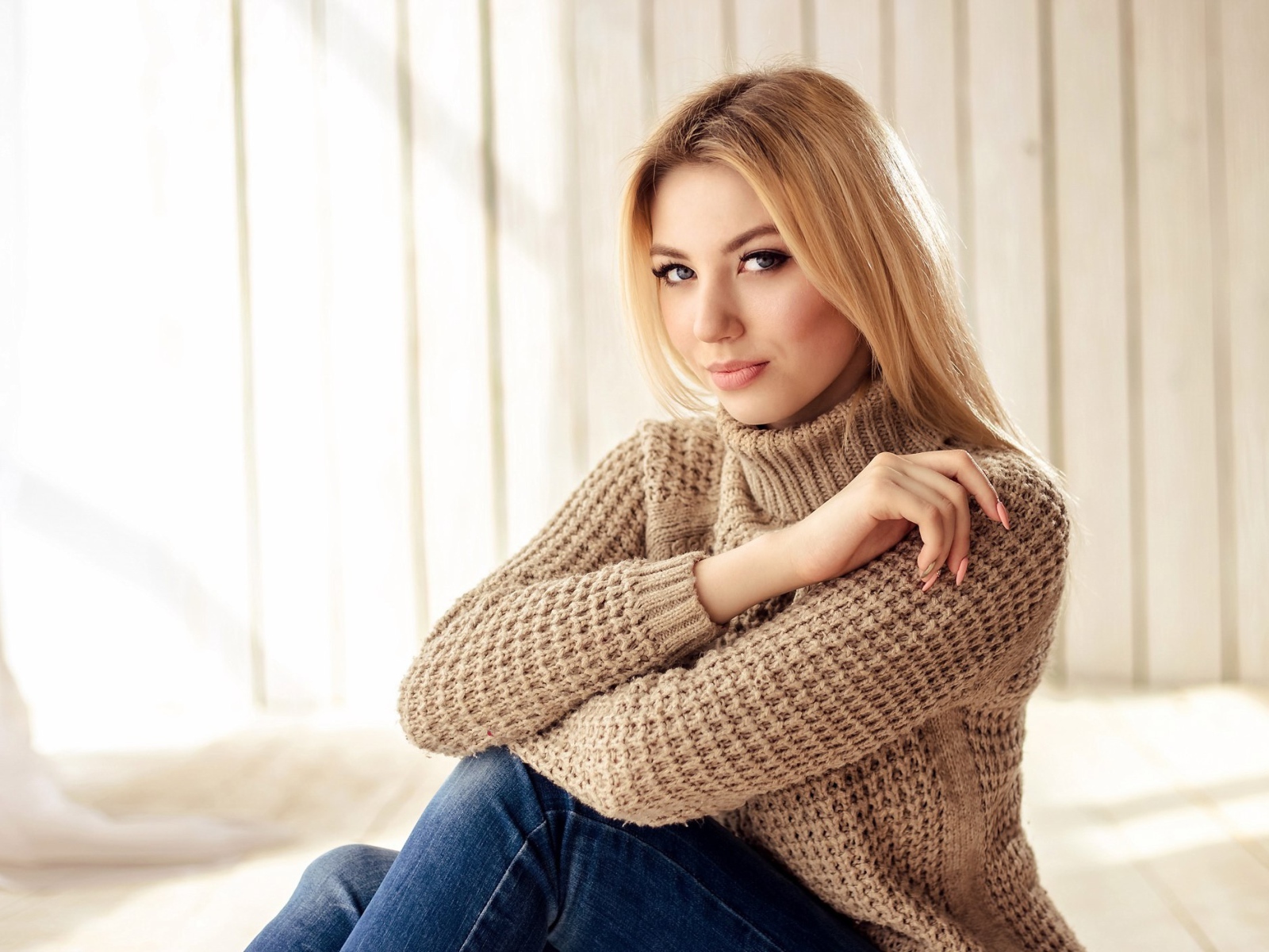 Красивая девушка блондинка с голубыми глазами в свитере 