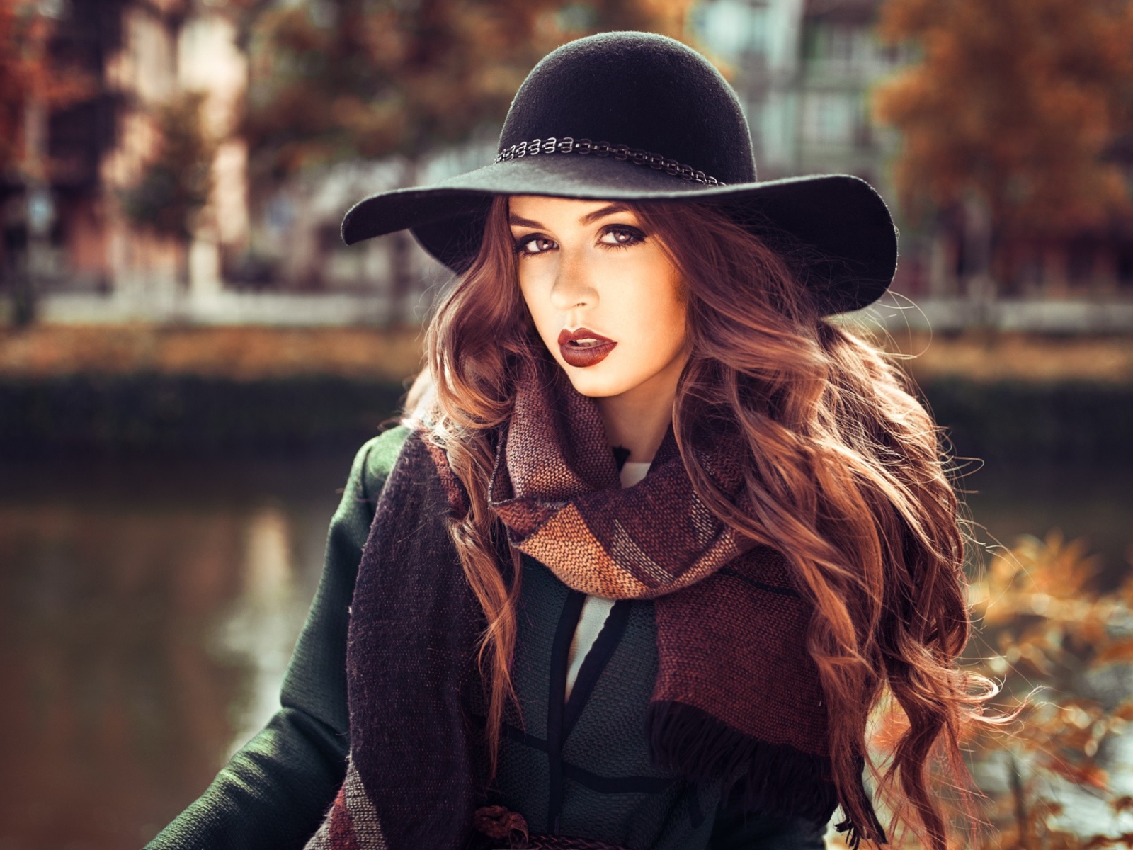 Красивая девушка брюнетка в большой черной шляпе 