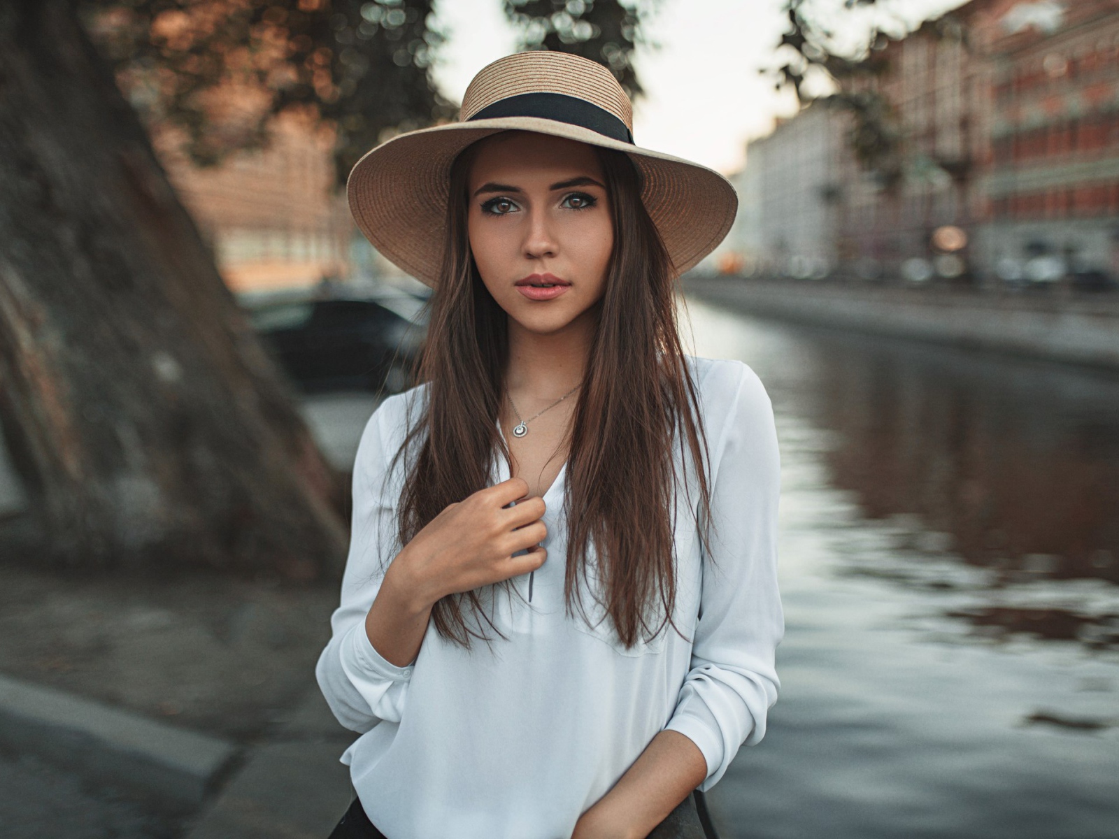 Красивая девушка брюнетка в шляпе у воды