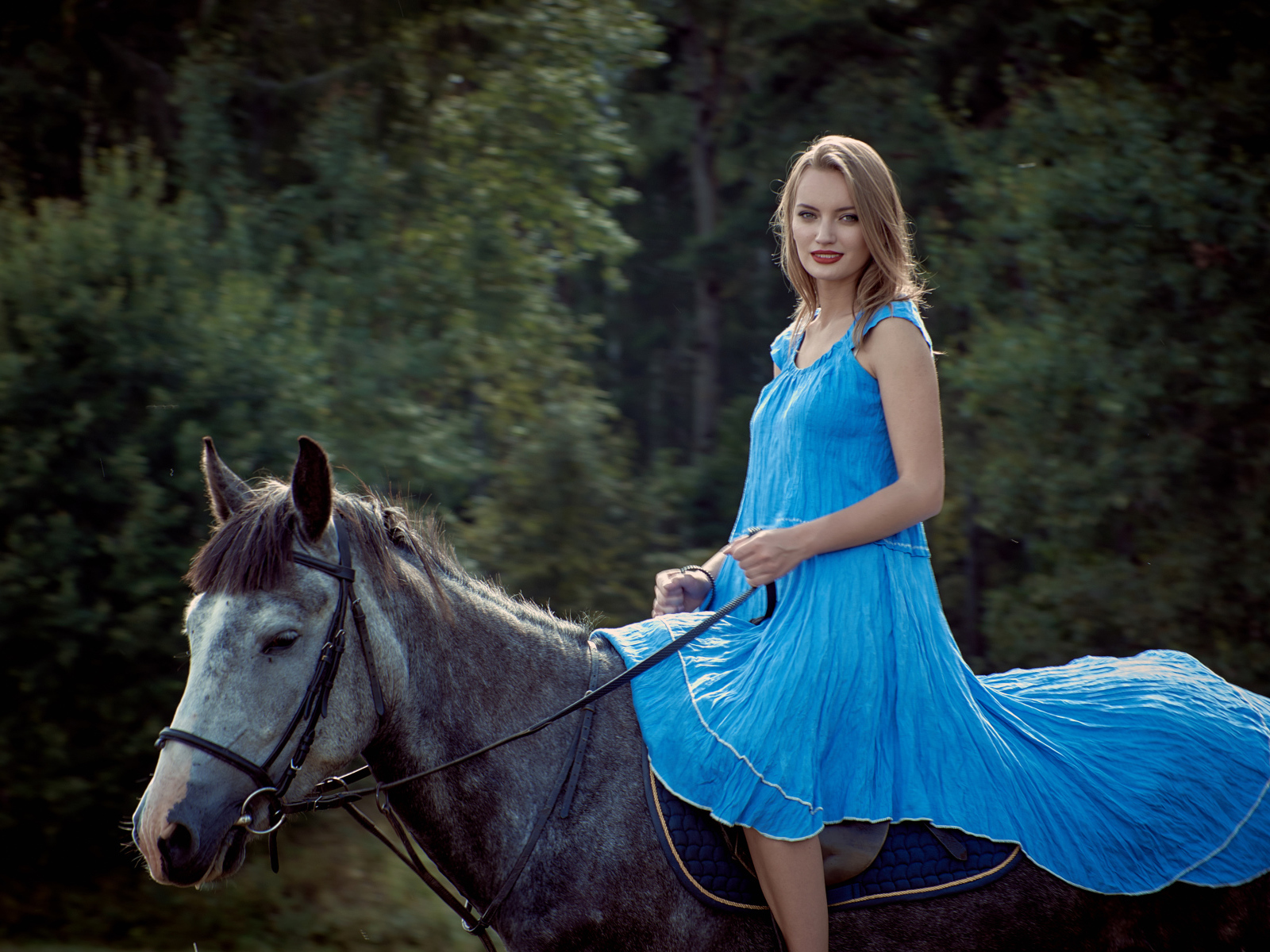 Девушка блондинка в голубом платье на лошади
