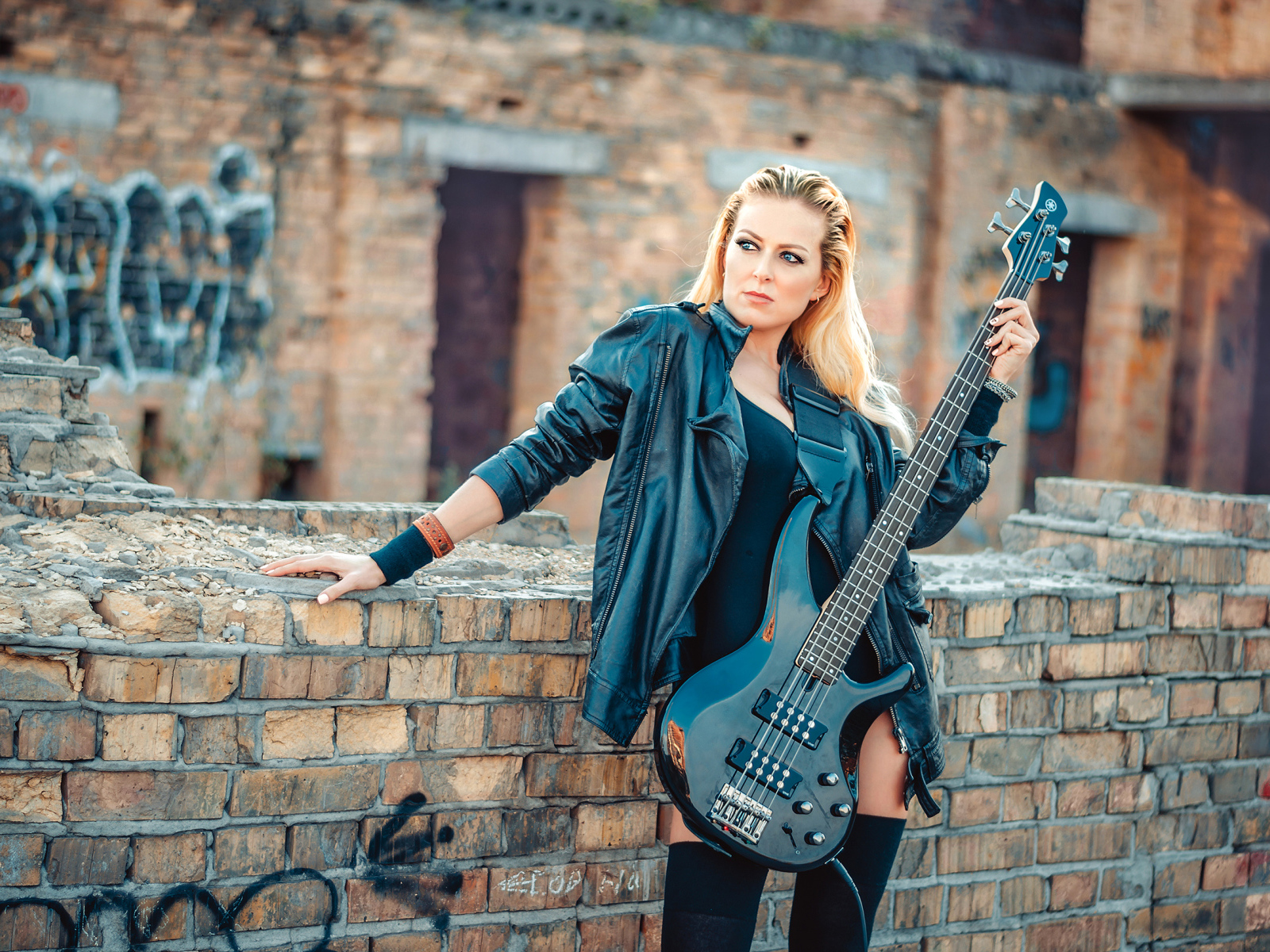 Блондинка в кожаной куртке с электрогитарой в руках