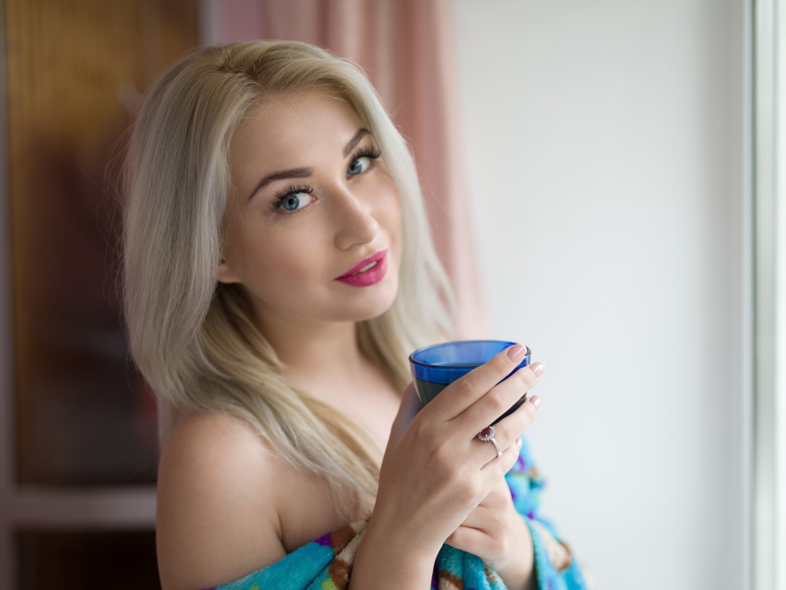 Блондинка с розовыми губами и стаканом в руках 