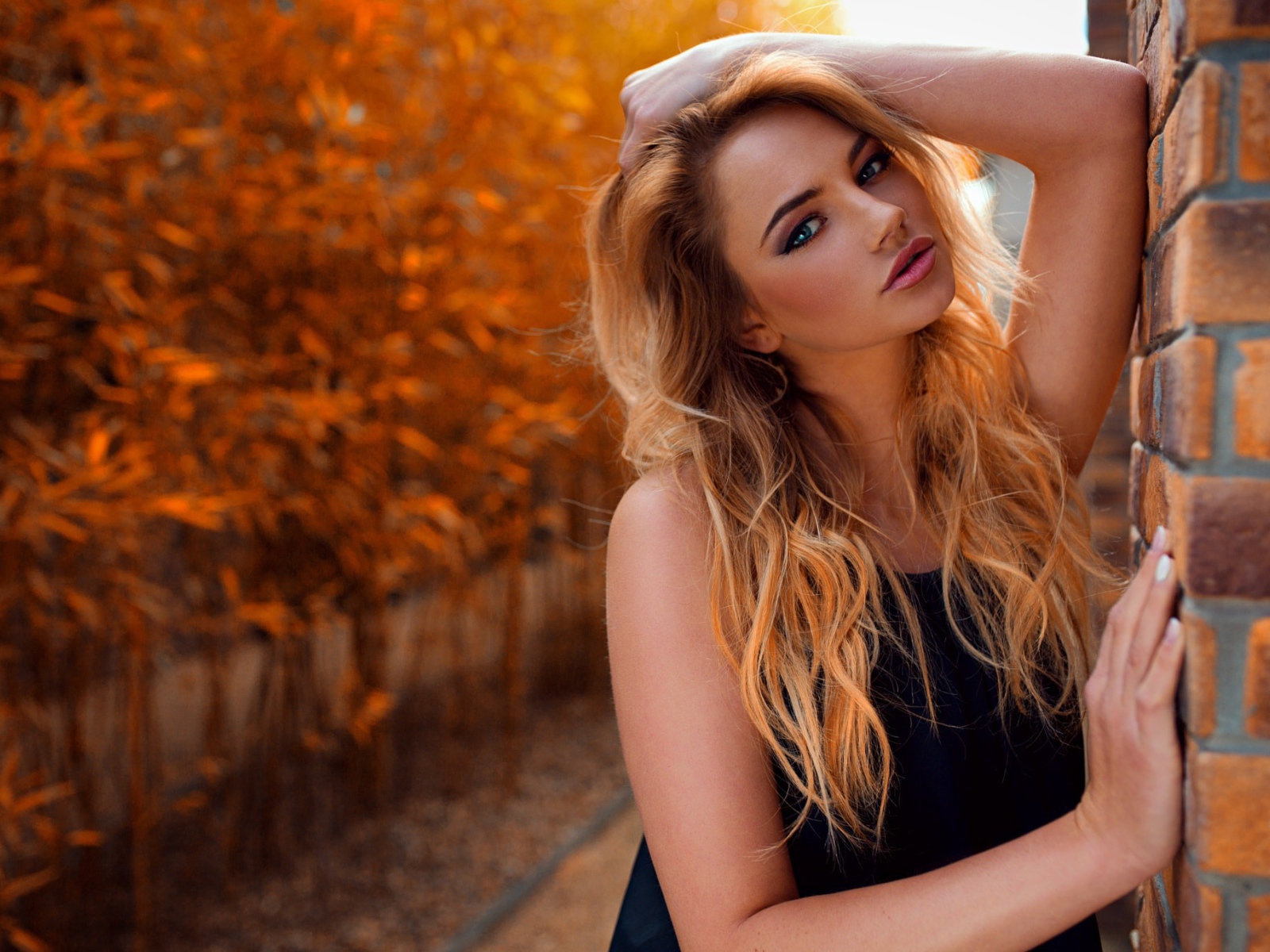 Голубоглазая девушка блондинка у стены 