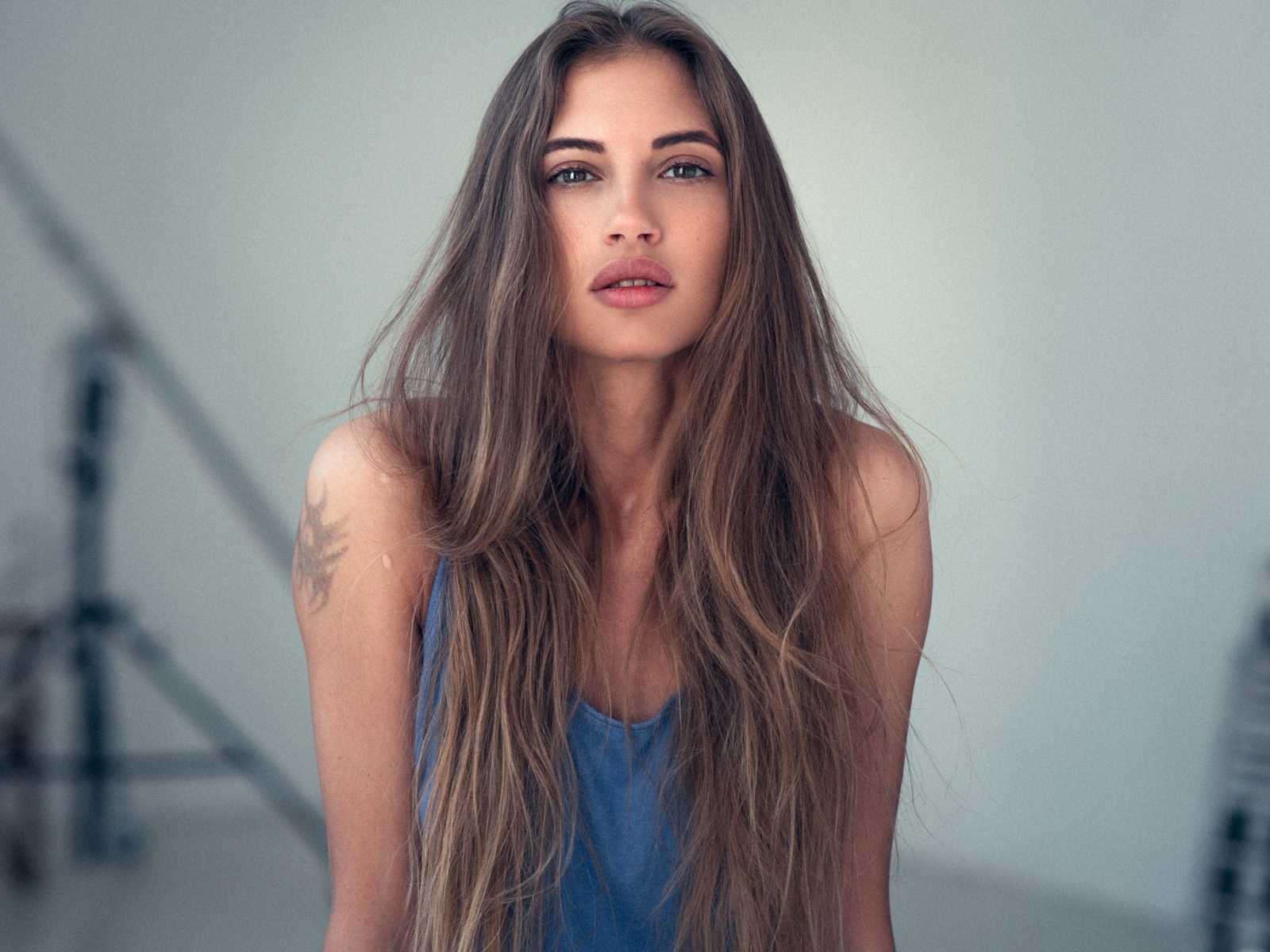 Девушка с длинными волосами и татуировкой на плече 