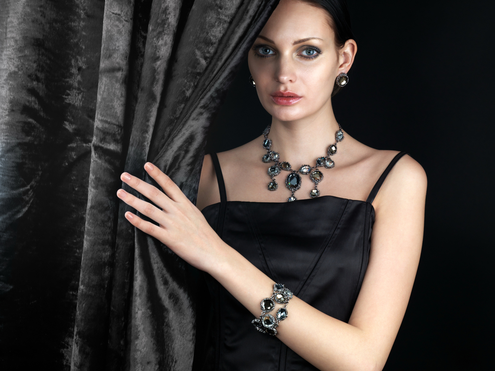 Эффектная девушка в черном платье и дорогих украшениях