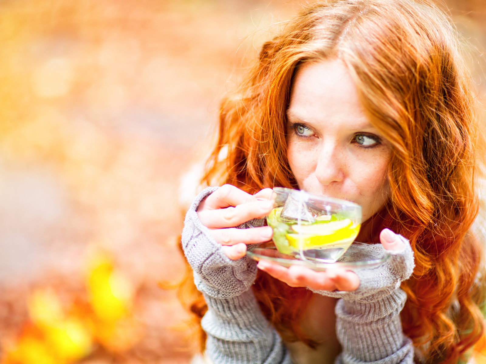 Рыжеволосая девушка модель с чашкой зеленого чая 