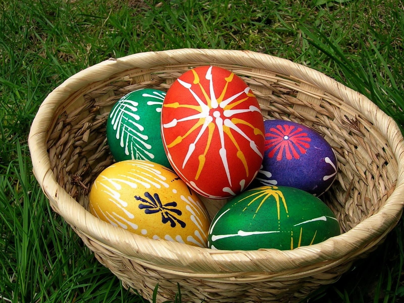 Пасхальные яйца с красивыми узорами в корзине 