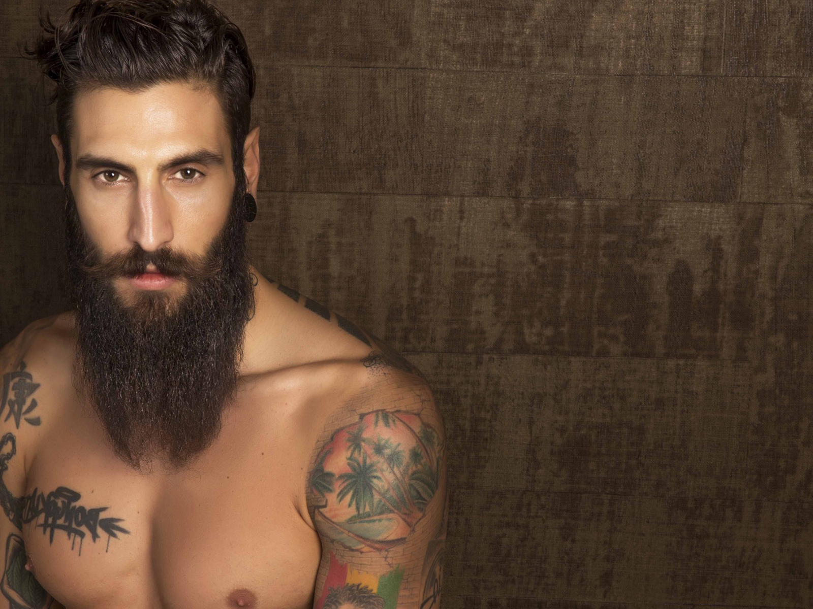 Молодой парень модель Маттео Маринелли с бородой и татуировками на теле
