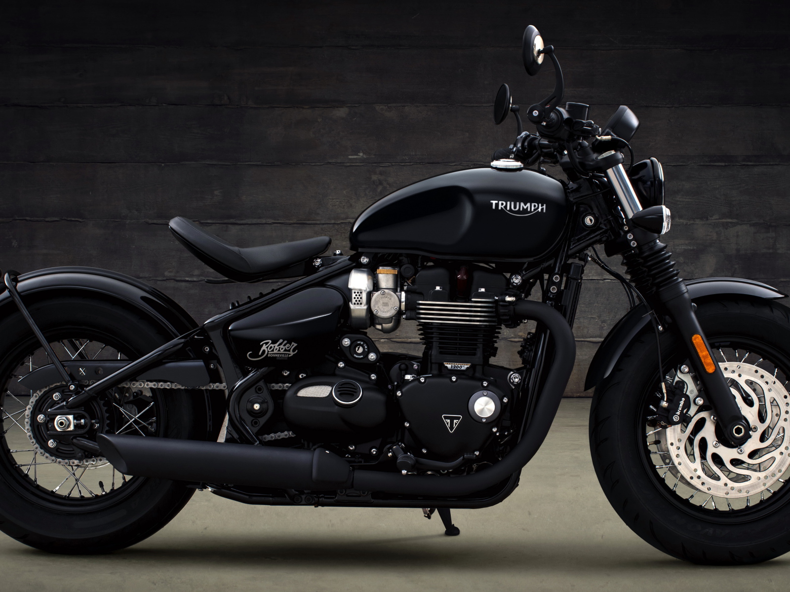 Черный мотоцикл Triumph Bonneville Bobber, 2018 вид сбоку