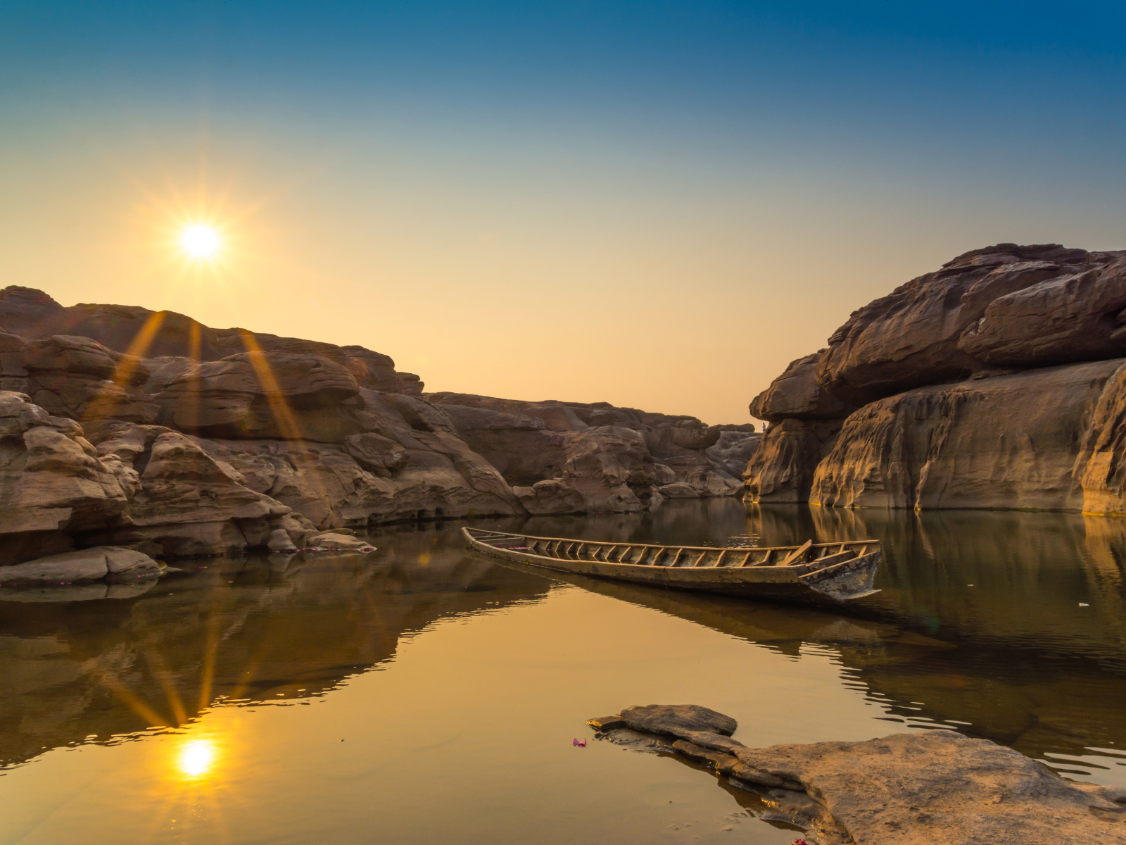 Лодна на озере между скал на рассвете