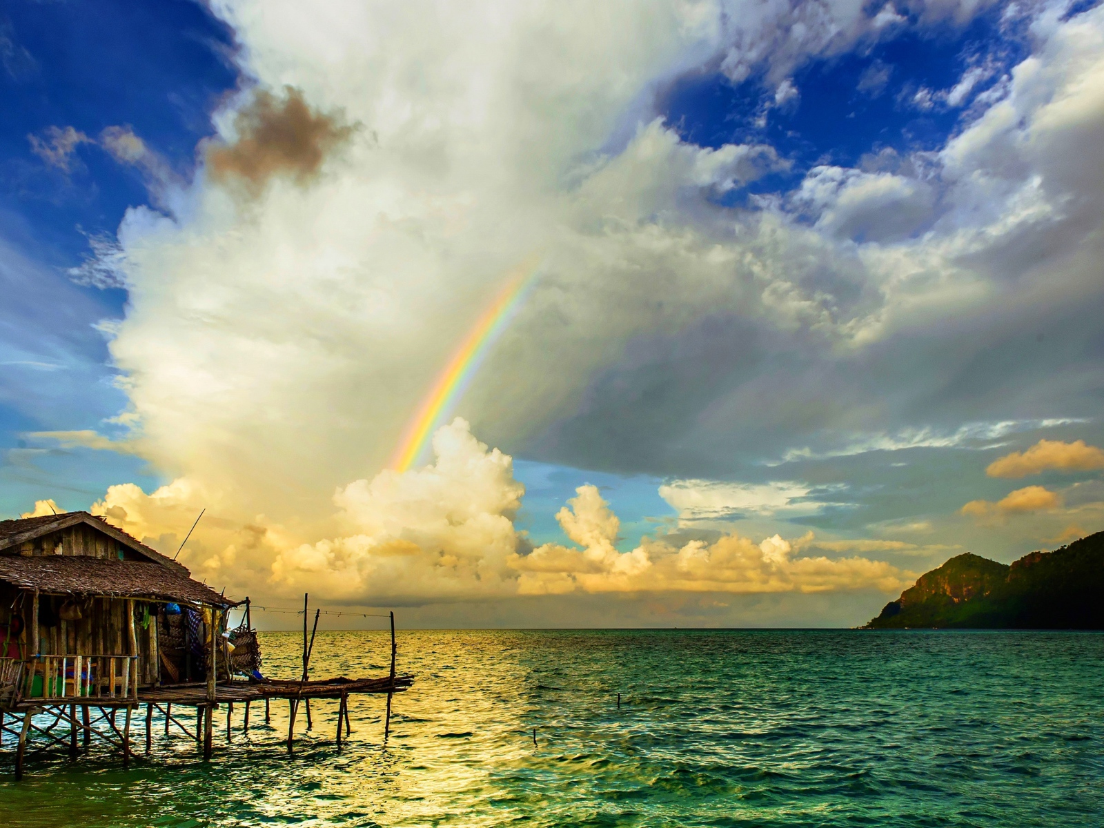 Радуга  над бунгало на тропическим пляжем 