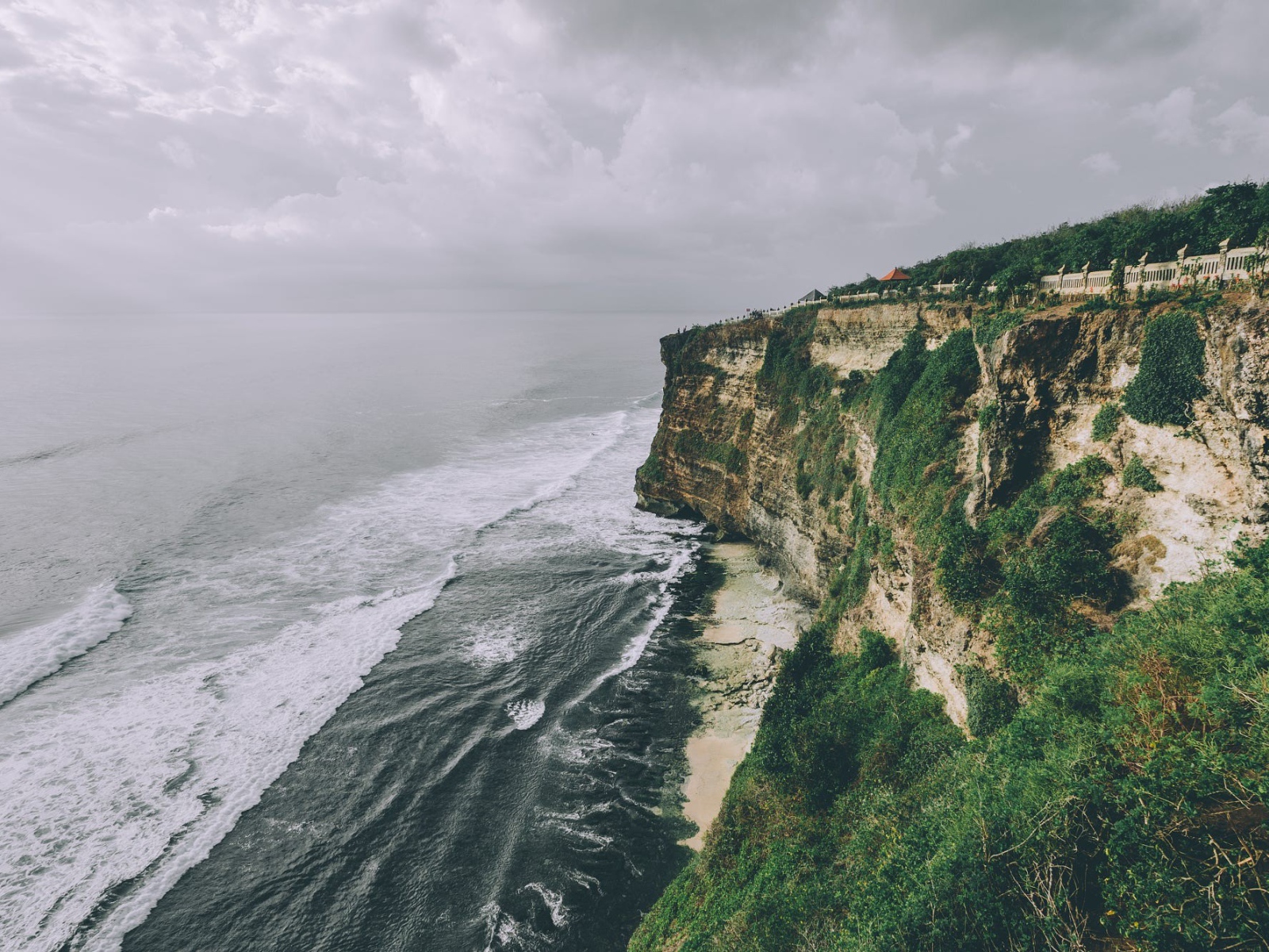 Бушующие волны у зеленого утеса 