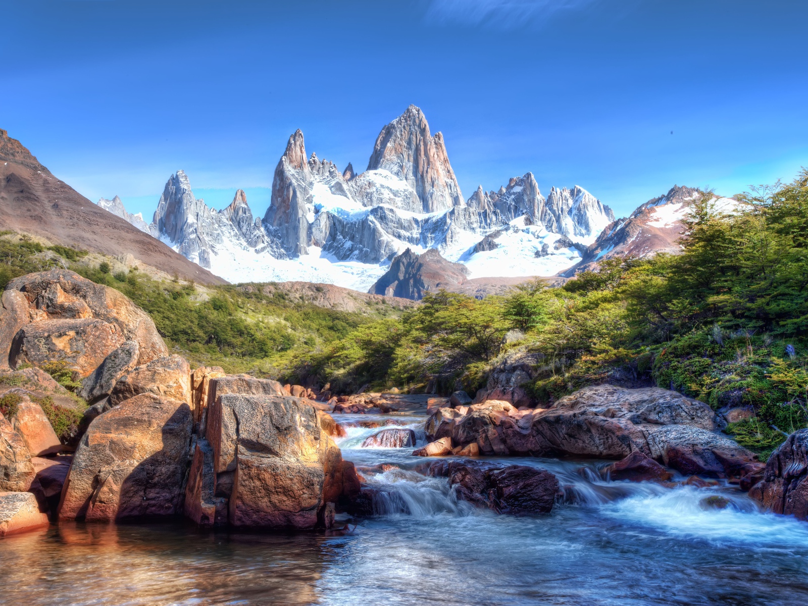 Вид на заснеженные кавказские горы и озеро