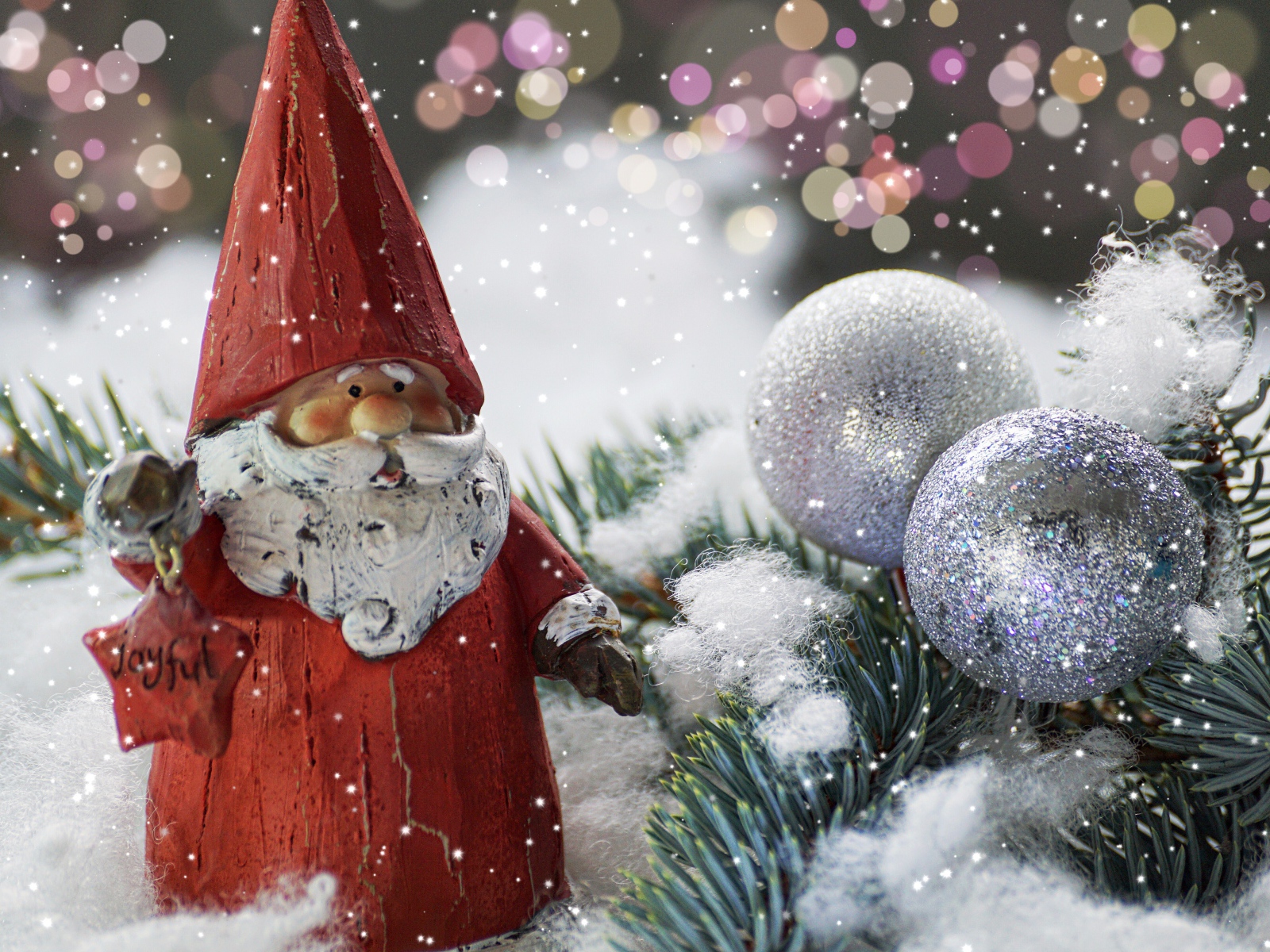 Статуэтка деда Мороза рядом с еловой веткой и яркими шарами