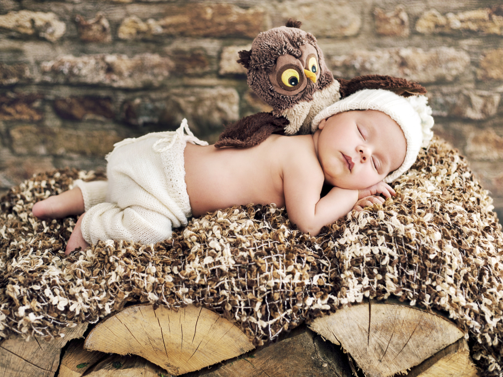 Грудной ребенок спит рядом с игрушкой совой