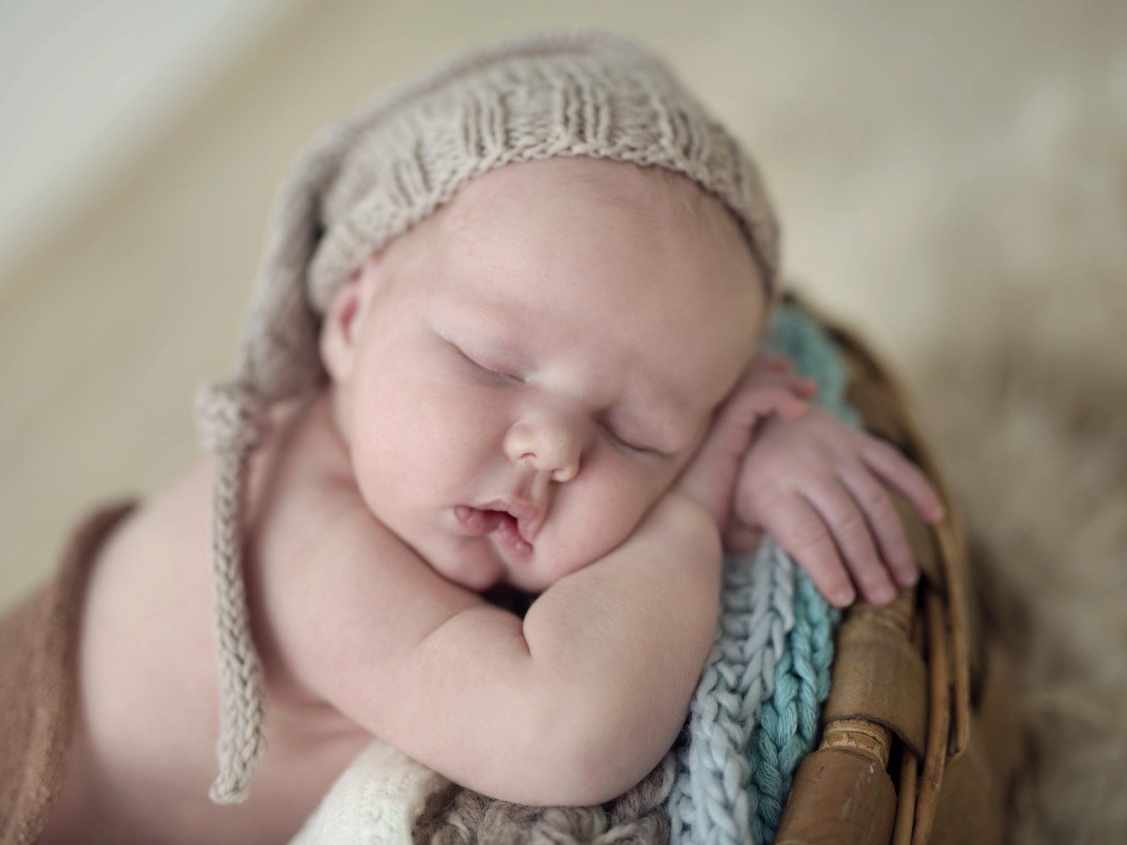Маленький грудной ребенок спит в вязаной шапке