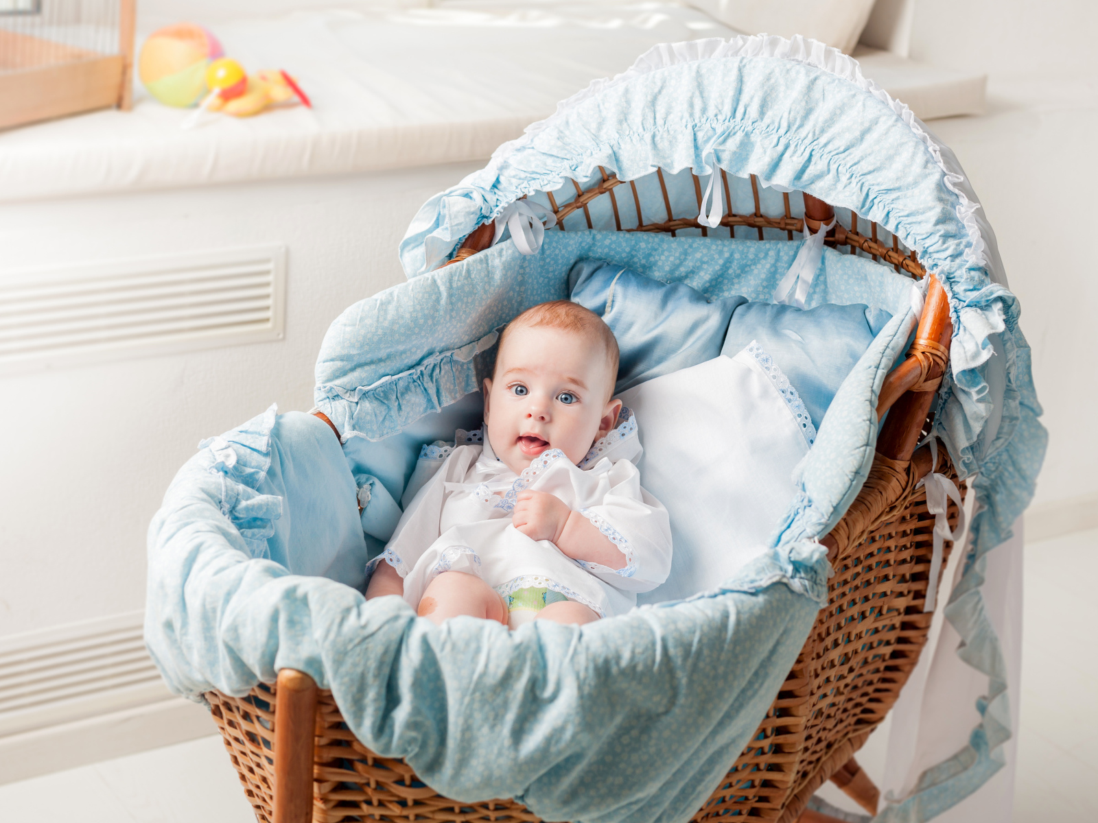 Маленький голубоглазый младенец в кроватке