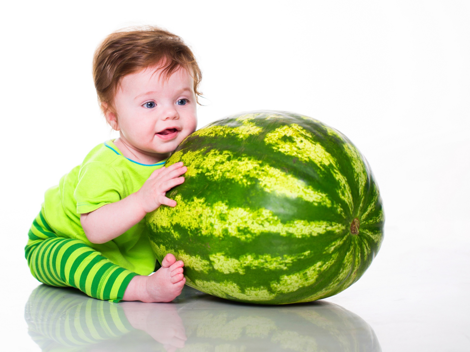Маленький голубоглазый мальчик с большим зеленым арбузом
