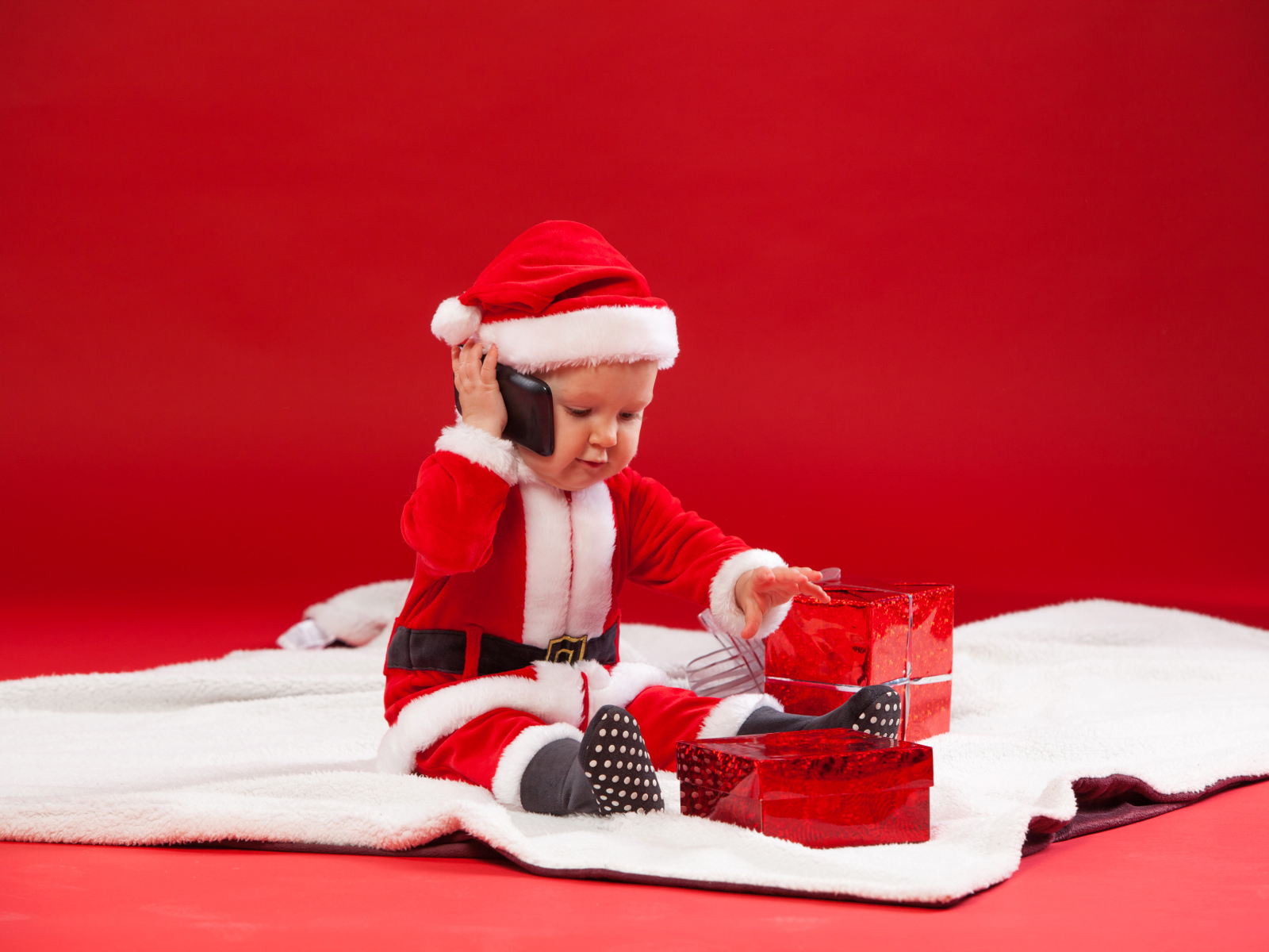 Маленький ребенок в новогодней униформе с подарками
