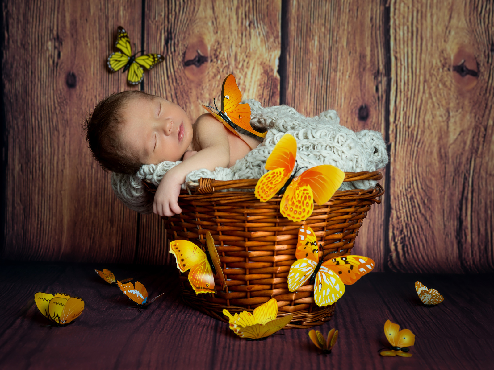 Милый спящий младенец в корзине с бабочками