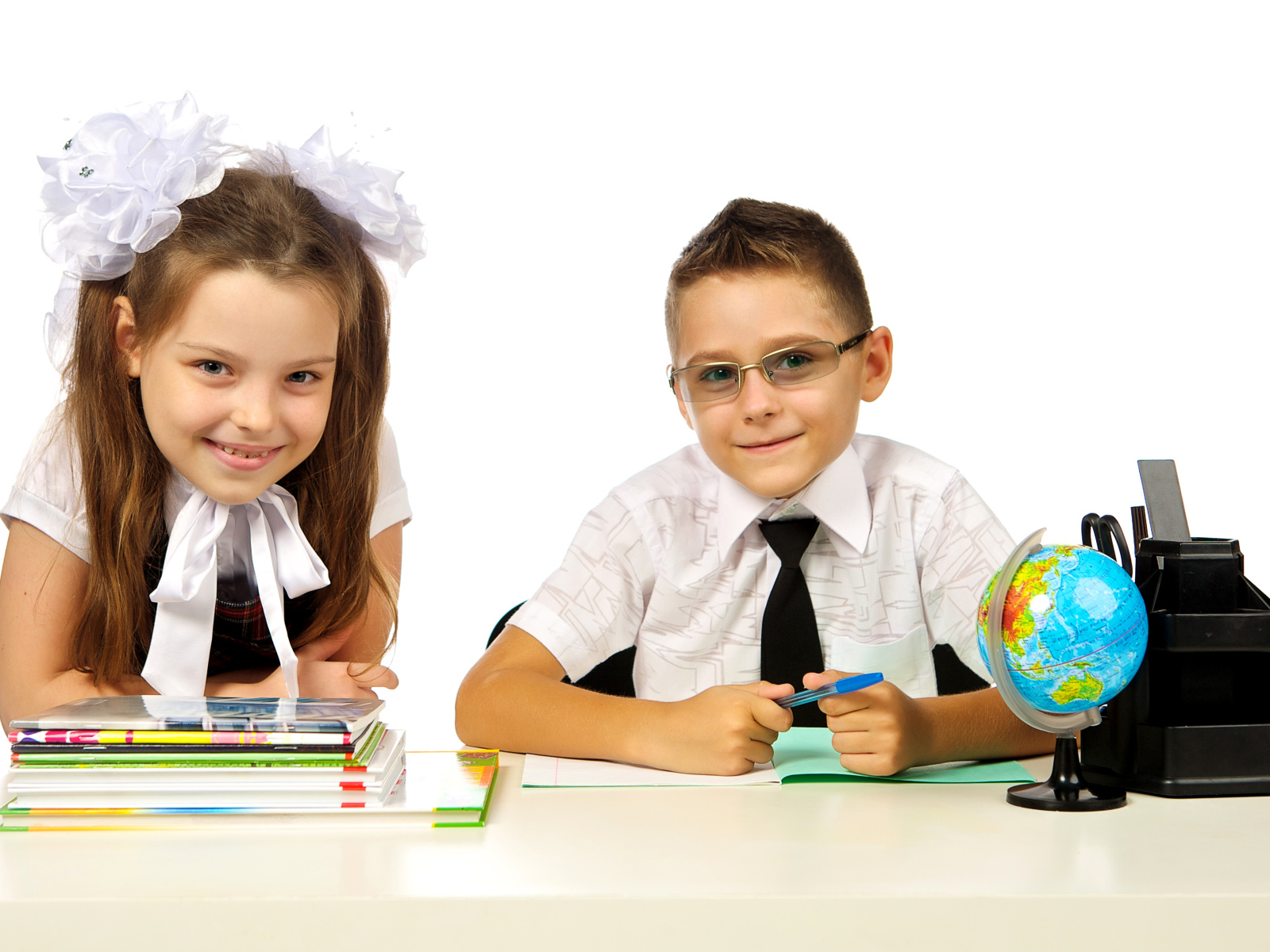 Маленькие мальчик и девочка школьники на белом фоне
