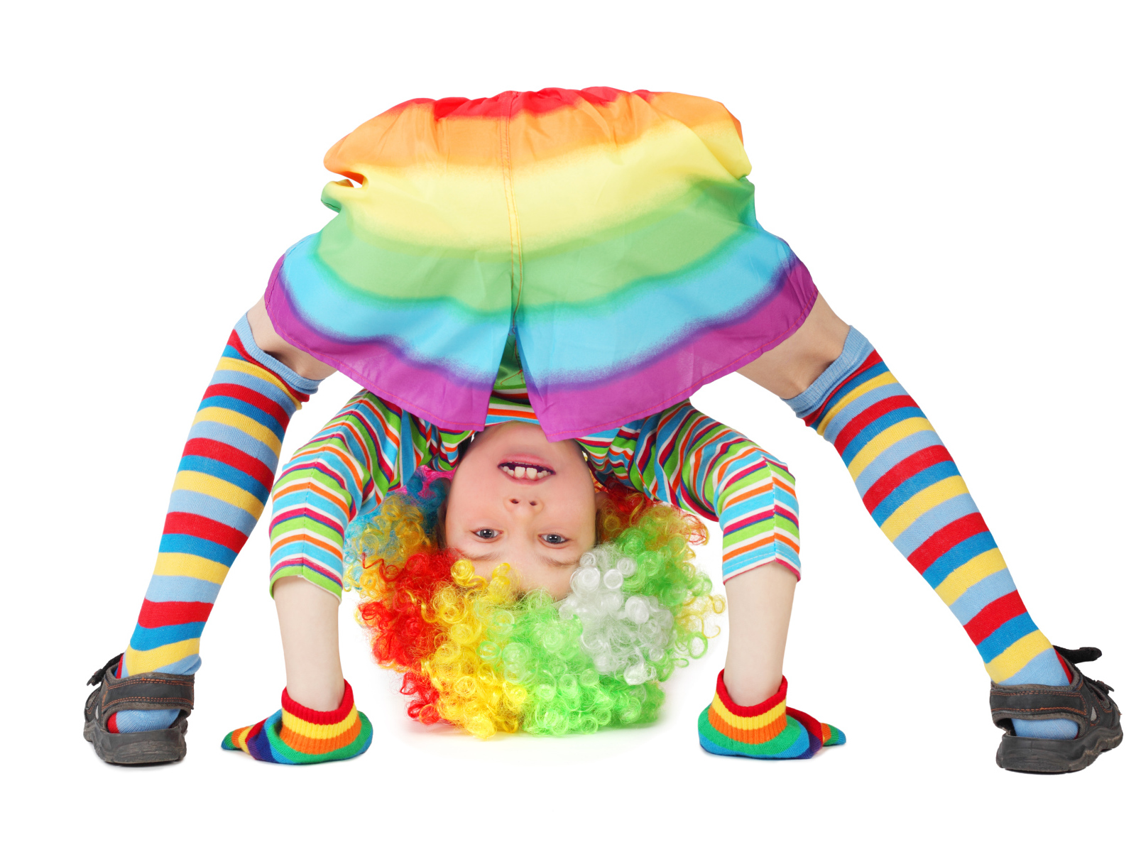 Маленькая смешная девочка в костюме клоуна на белом фоне