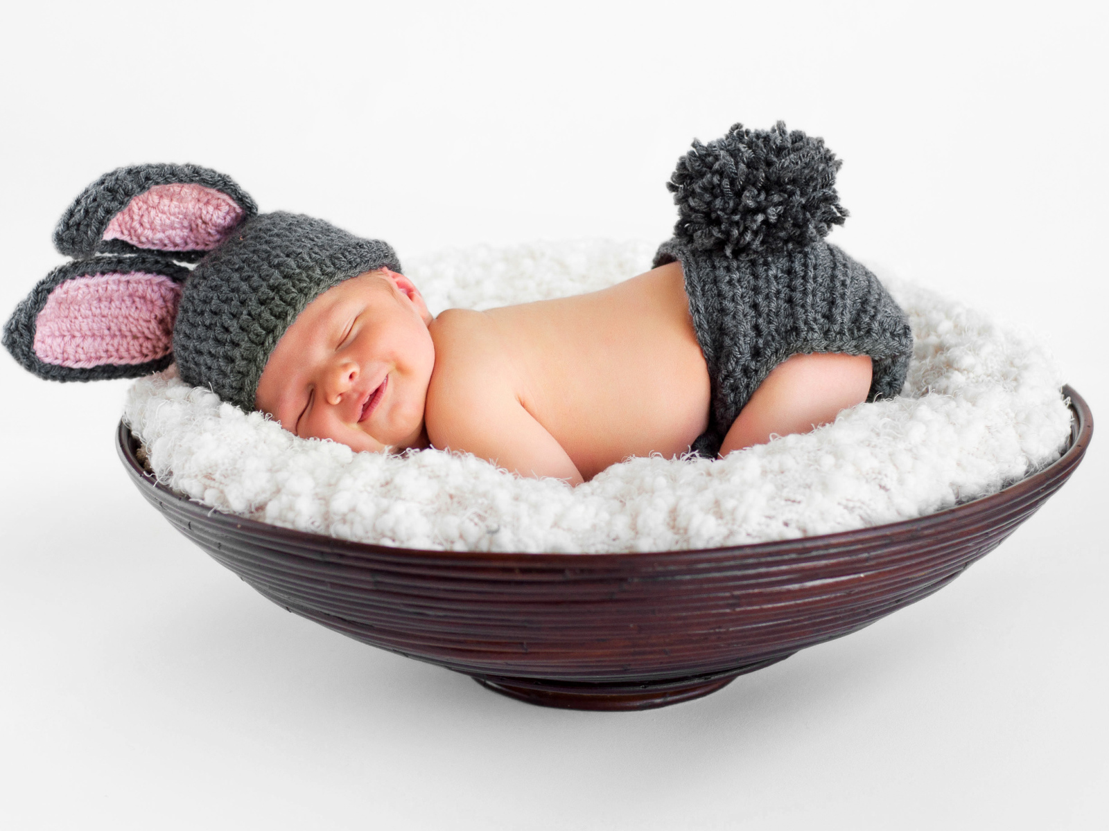 Маленький спящий грудной ребенок в вязаном костюме зайчика