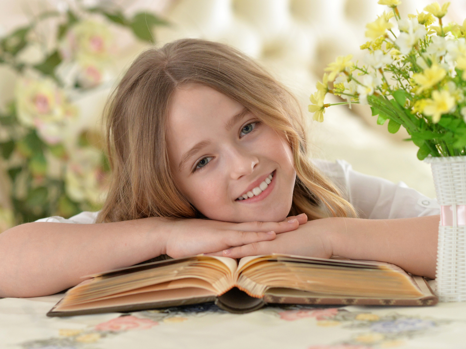 Улыбающаяся русоволосая девочка с книгой