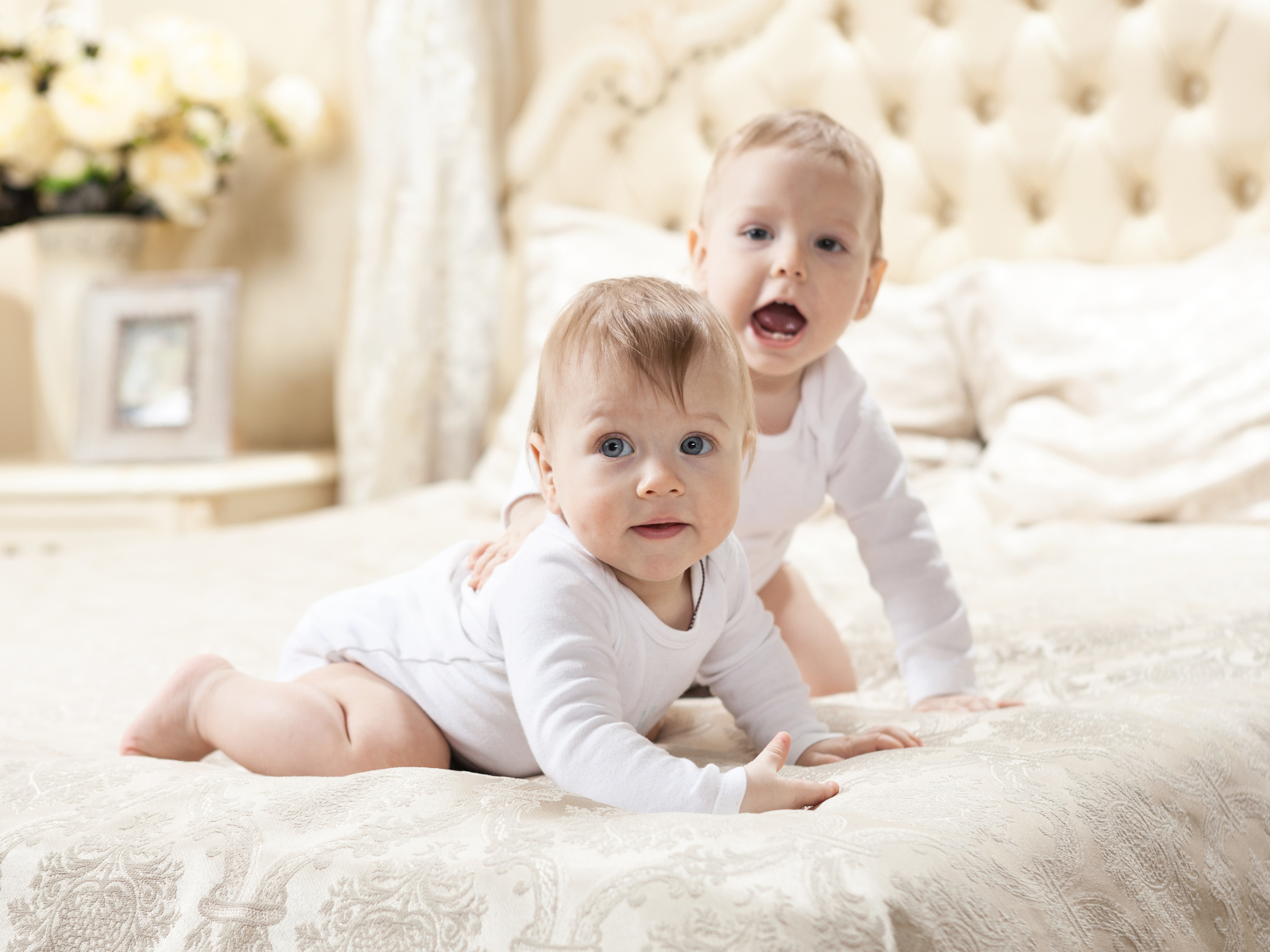 Два забавных младенца лежат на кровати