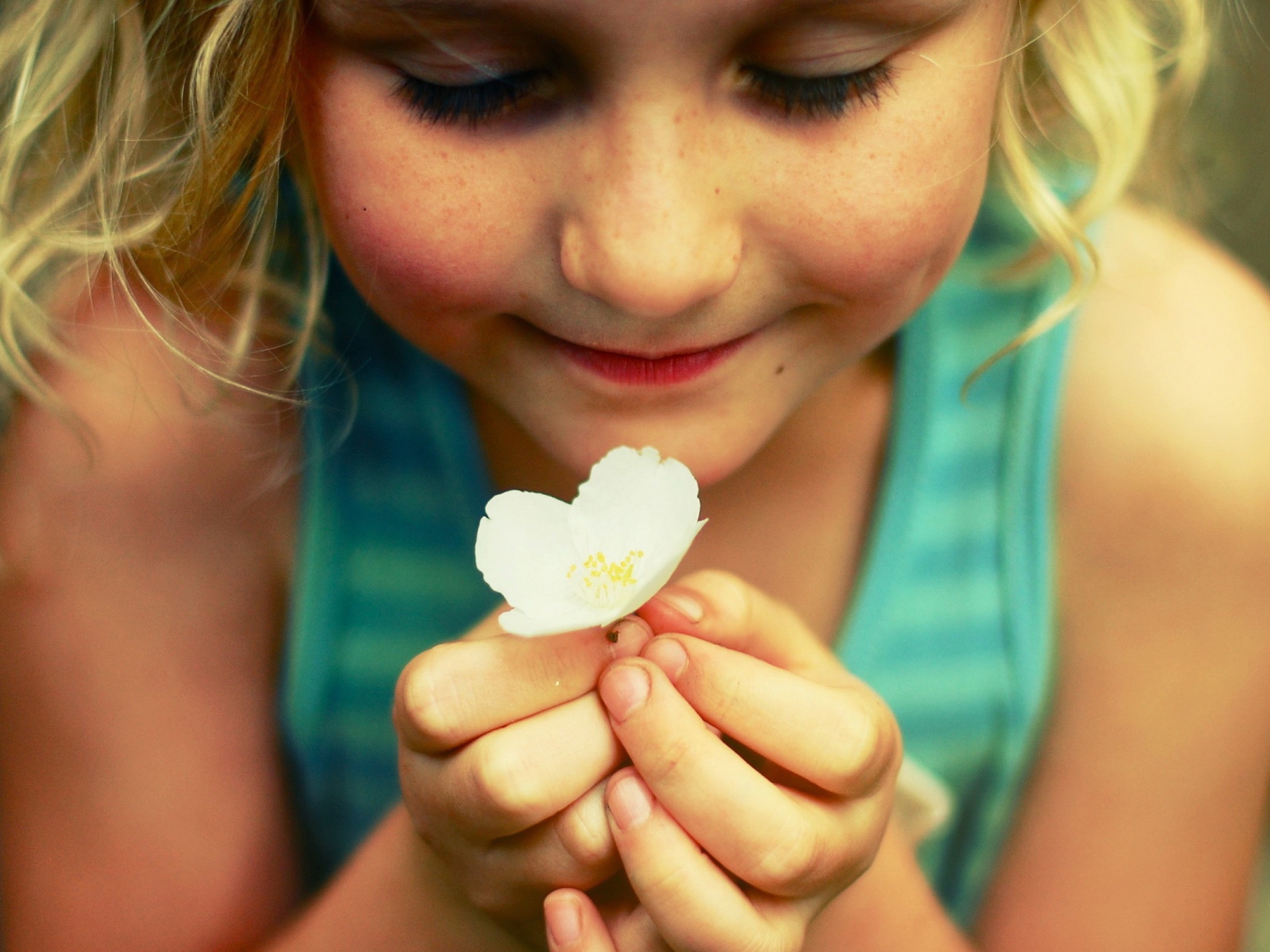 Маленькая девочка  держит белый цветок 