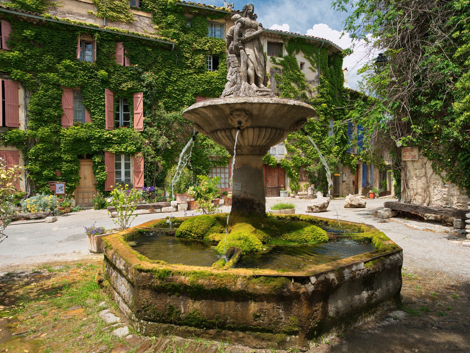 Старинный покрытый мхом фонтан на площади Сеньон, Франция