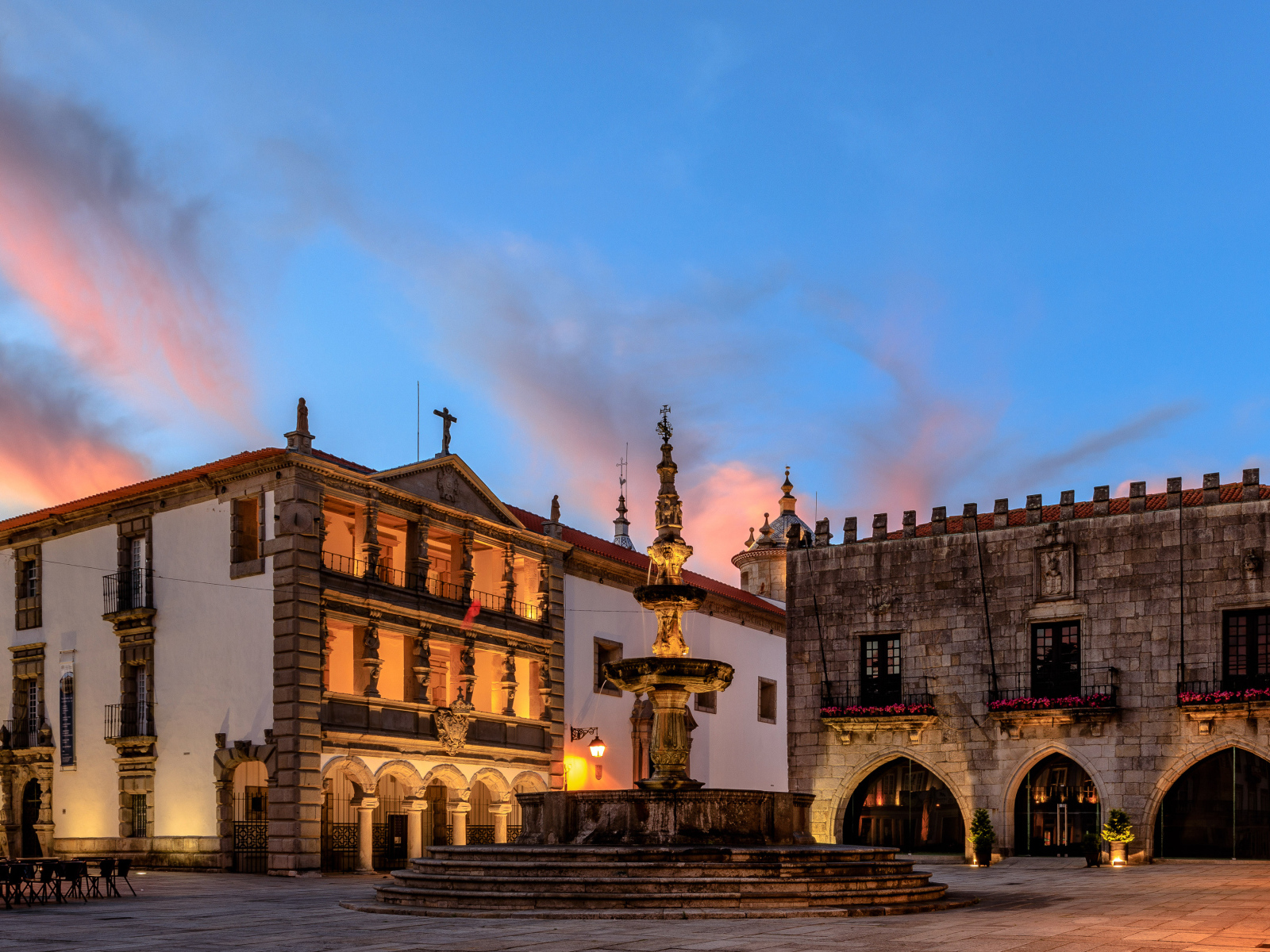 Дома и фонтан на вечерней площади в городе Вьяна, Португалия