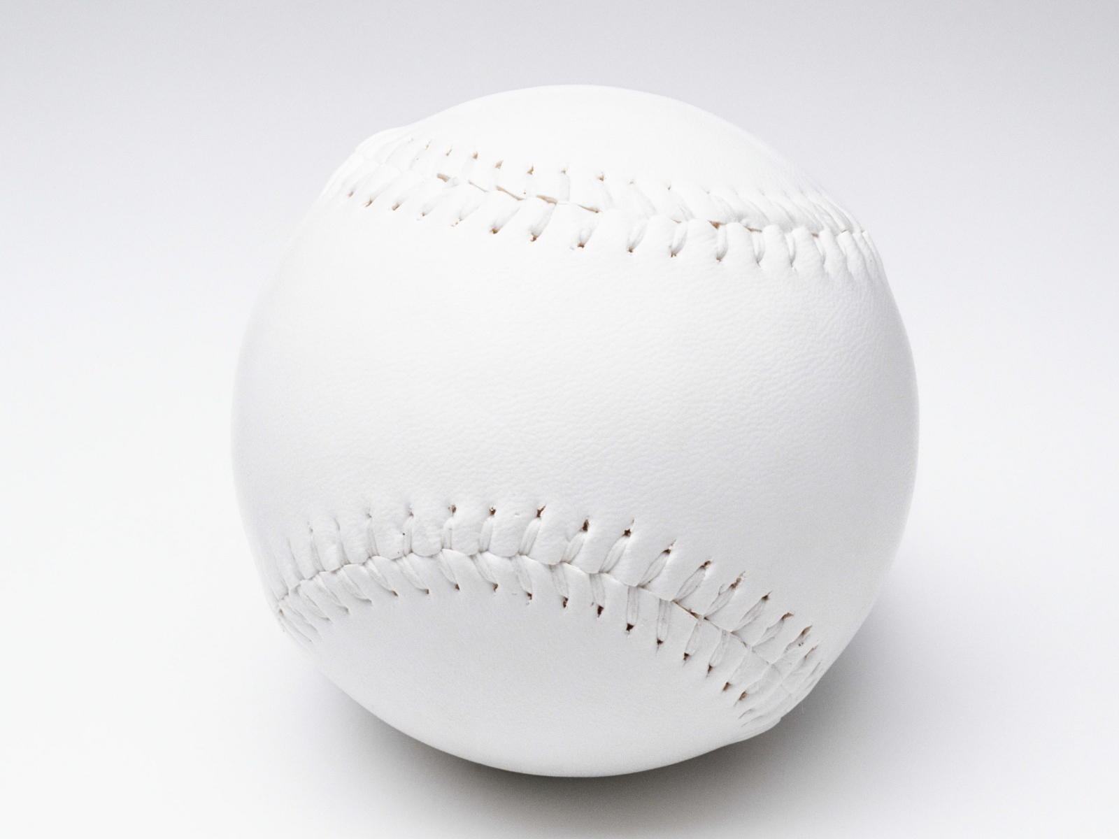 Белый бейсбольный мяч на белом фоне 
