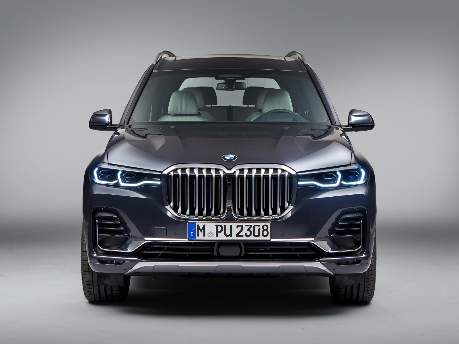 Автомобиль BMW X7  2018 года на сером фоне вид спереди