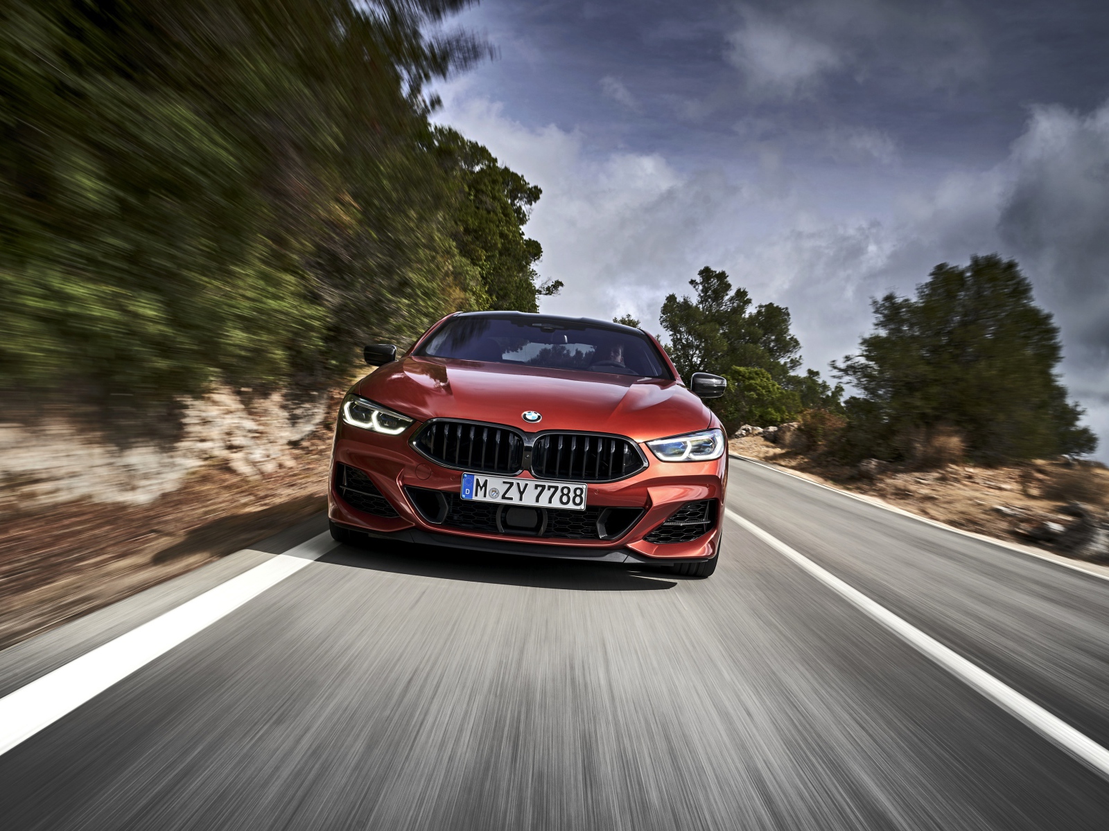 Бордовый автомобиль BMW 8 Series на трассе