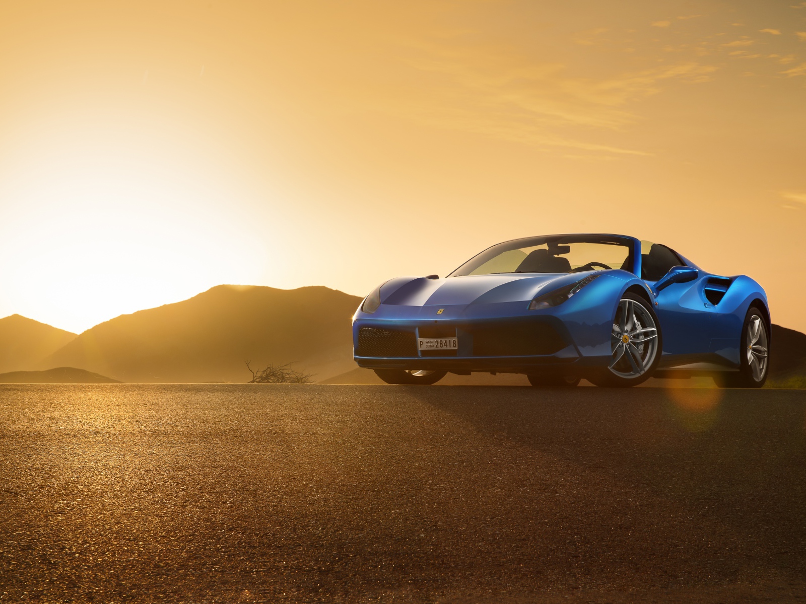 Синий автомобиль кабриолет Ferrari 488 Spider на рассвете