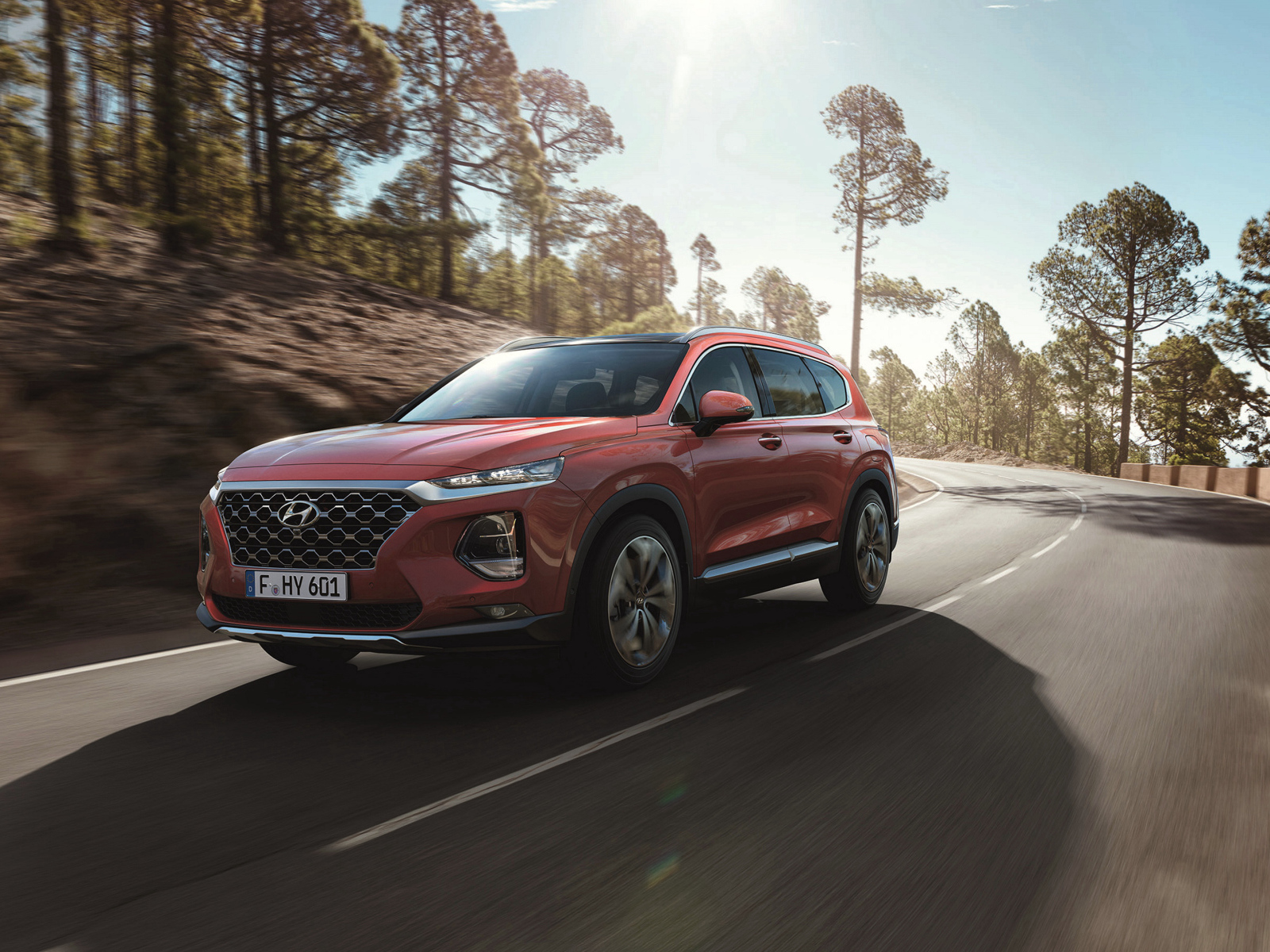 Красный автомобиль Hyundai Santa Fe, 2018 года на трассе