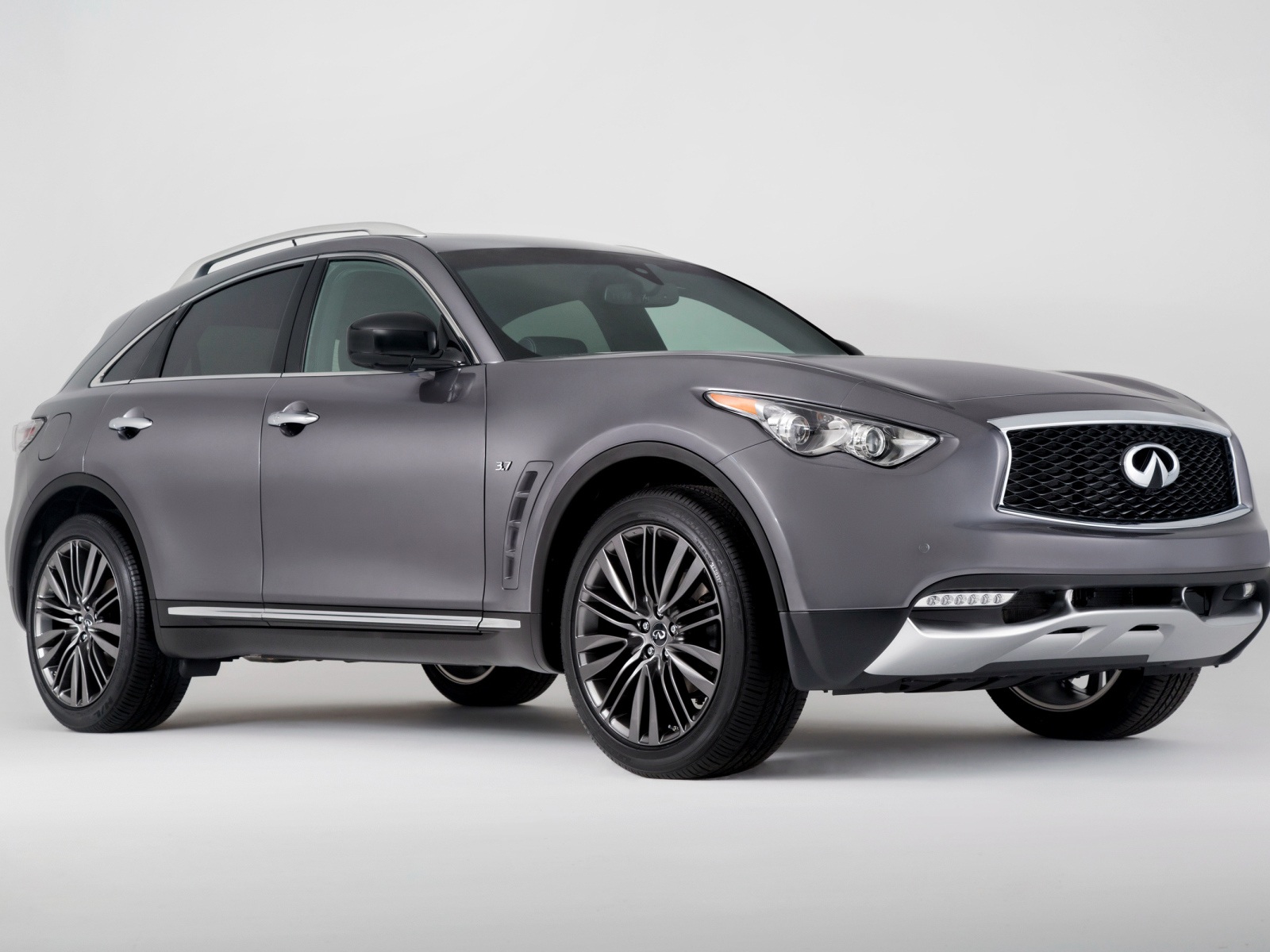 Серебристый автомобиль Infiniti QX70 на сером фоне