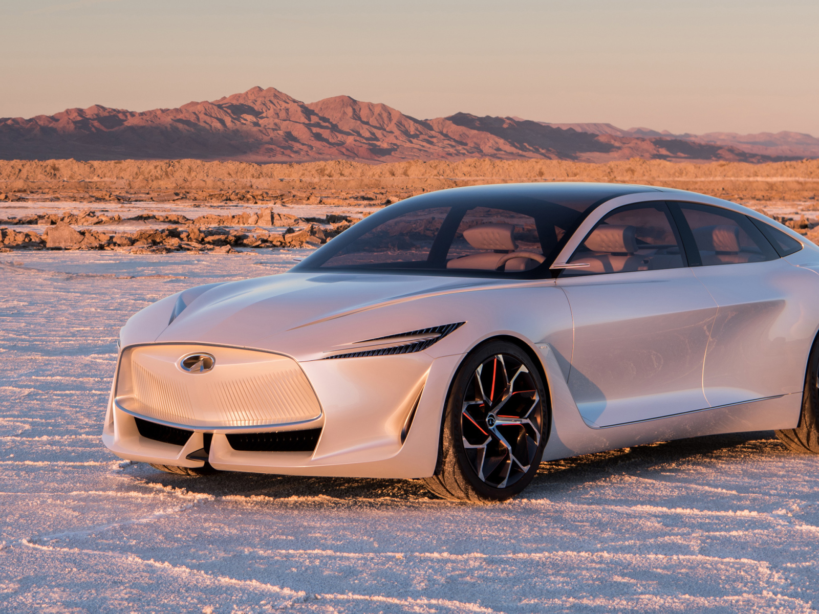 Серебристый автомобиль Infiniti Q Inspiration Concept, 2018 стоит на снегу на фоне гор