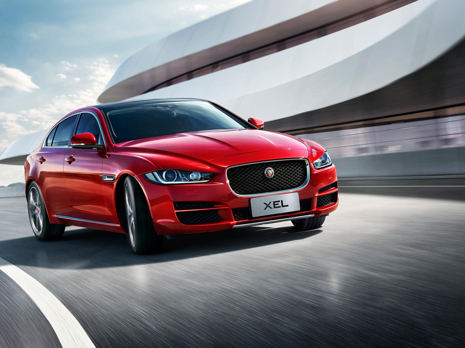 Красный автомобиль Jaguar XEL, 2018 на трассе
